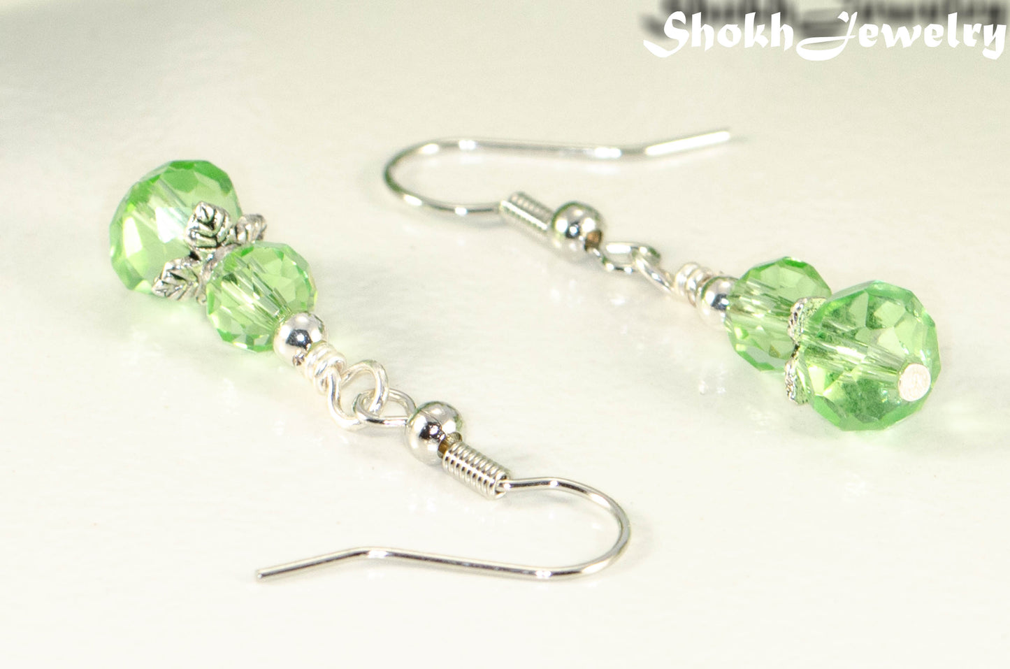 Close up of Small Light Green Glass Bead Dangle Earrings.