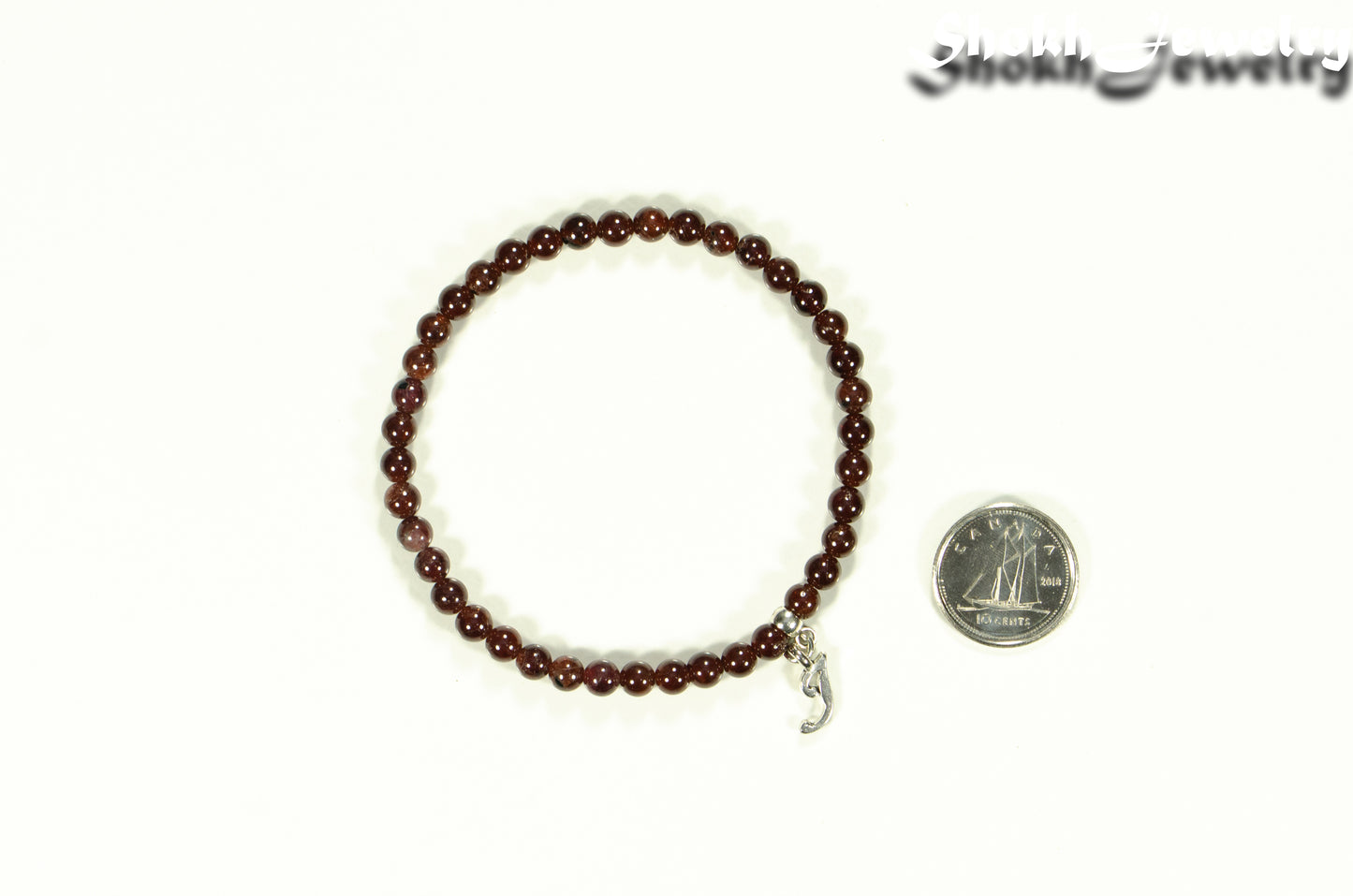 4mm Garnet Bracelet with Initial beside a dime.