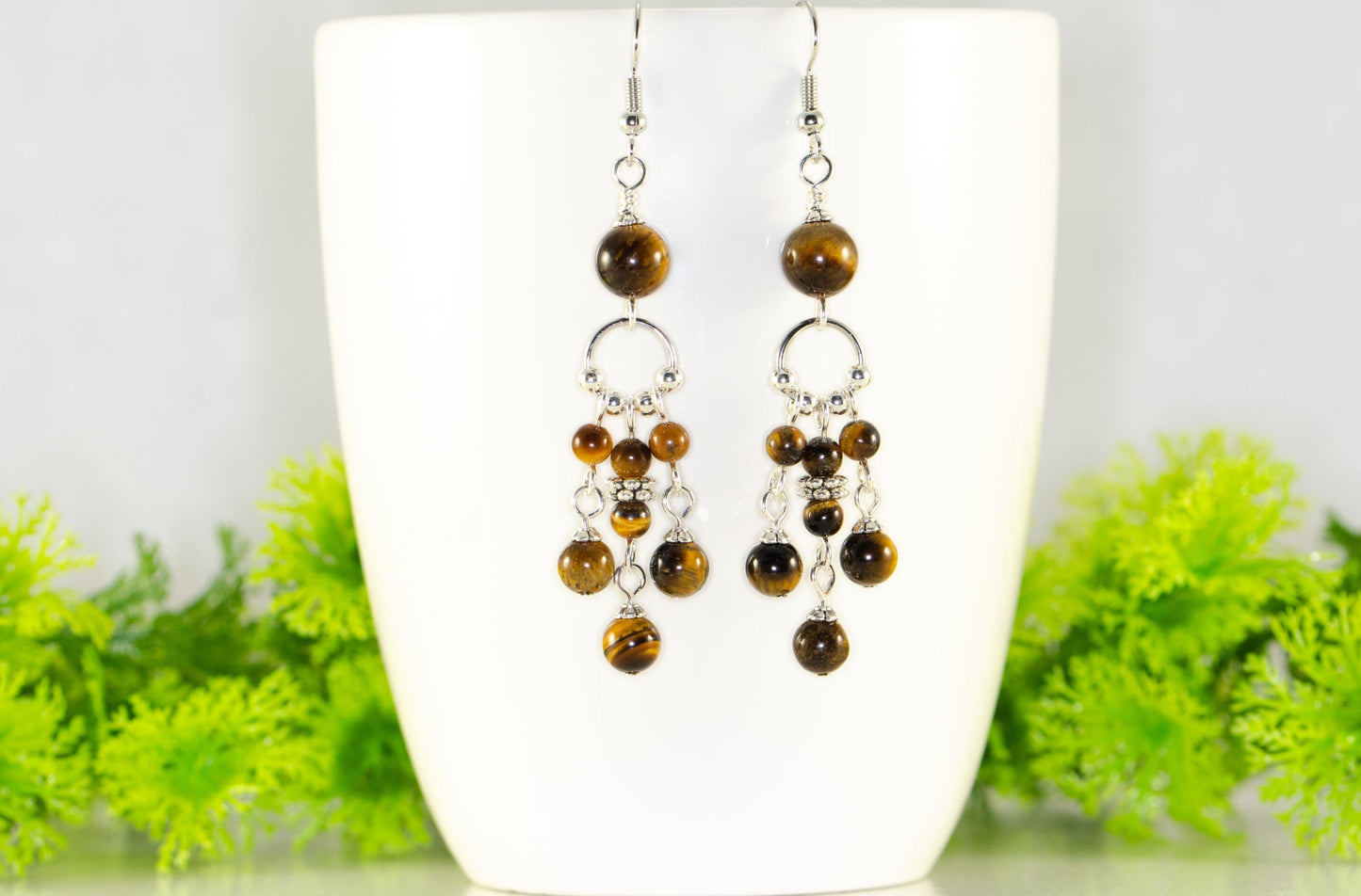Statement Tiger's Eye Chandelier Earrings displayed on a coffee mug.