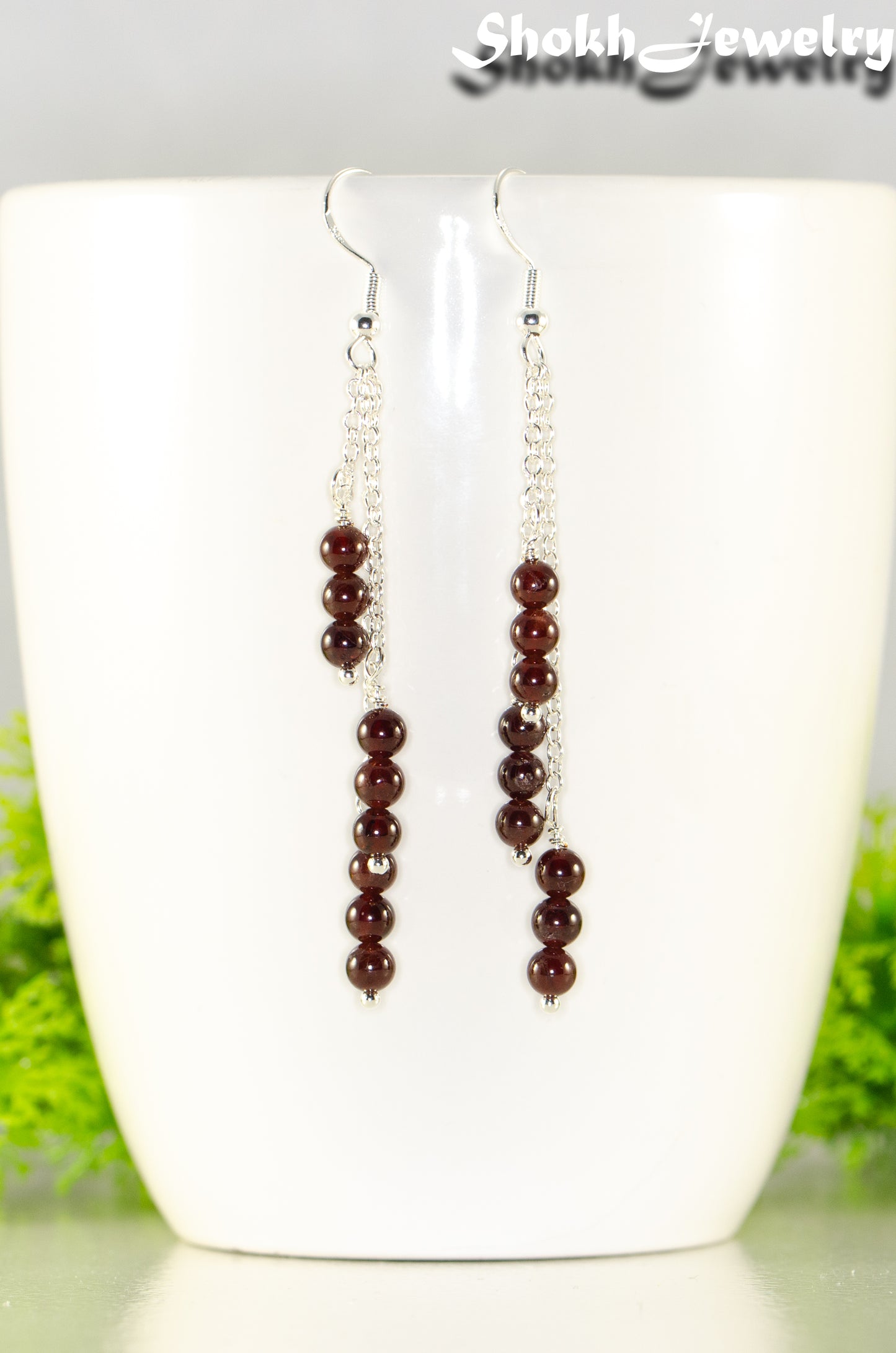 Close up of Silver Plated Chain and Garnet Crystal Earrings.