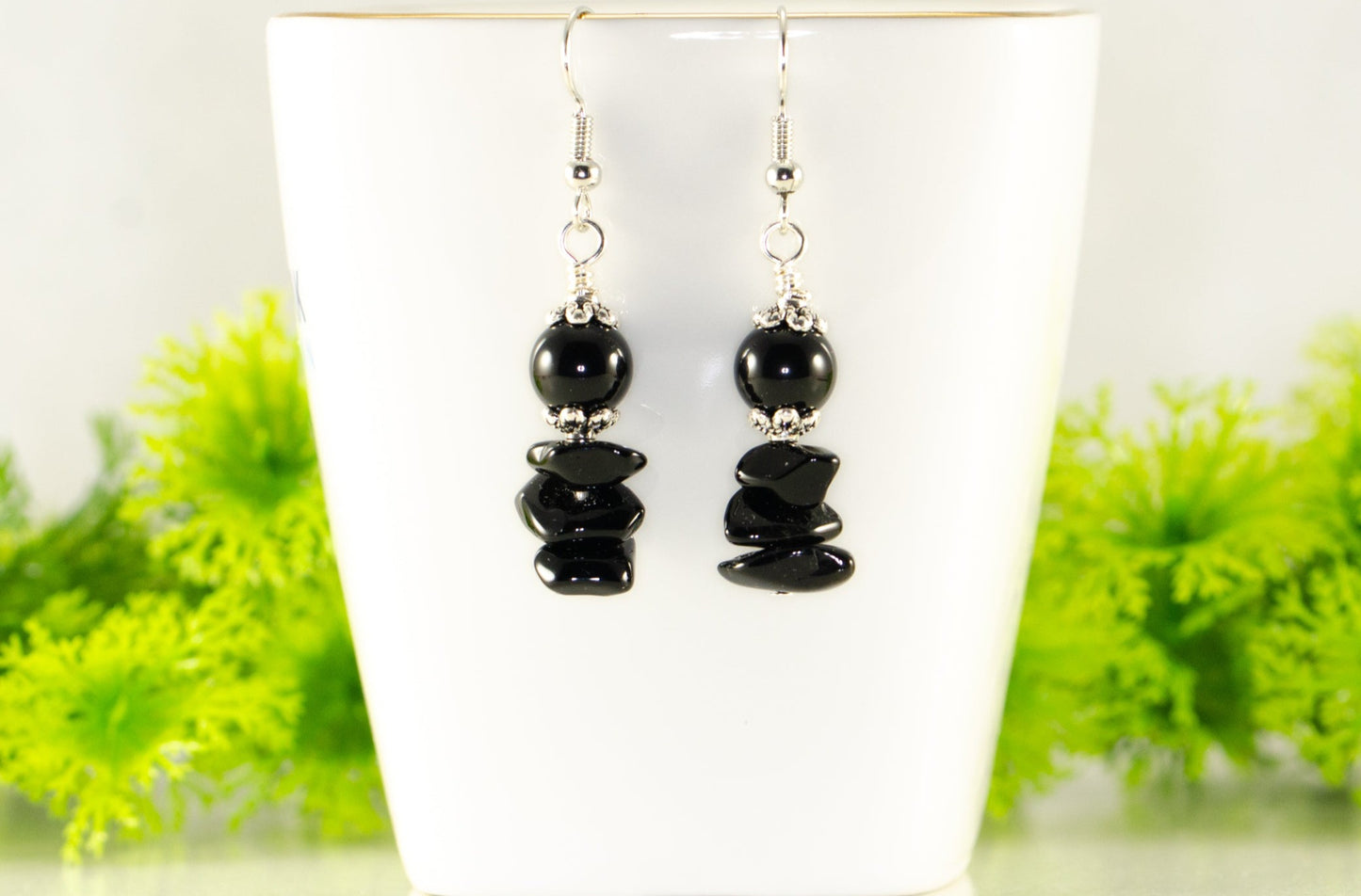 Simple Black Obsidian Crystal Chip Earrings displayed on a tea cup.