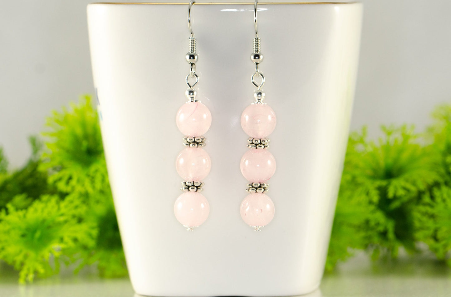 Natural Rose Quartz Beaded Bar Earrings displayed on a tea cup.