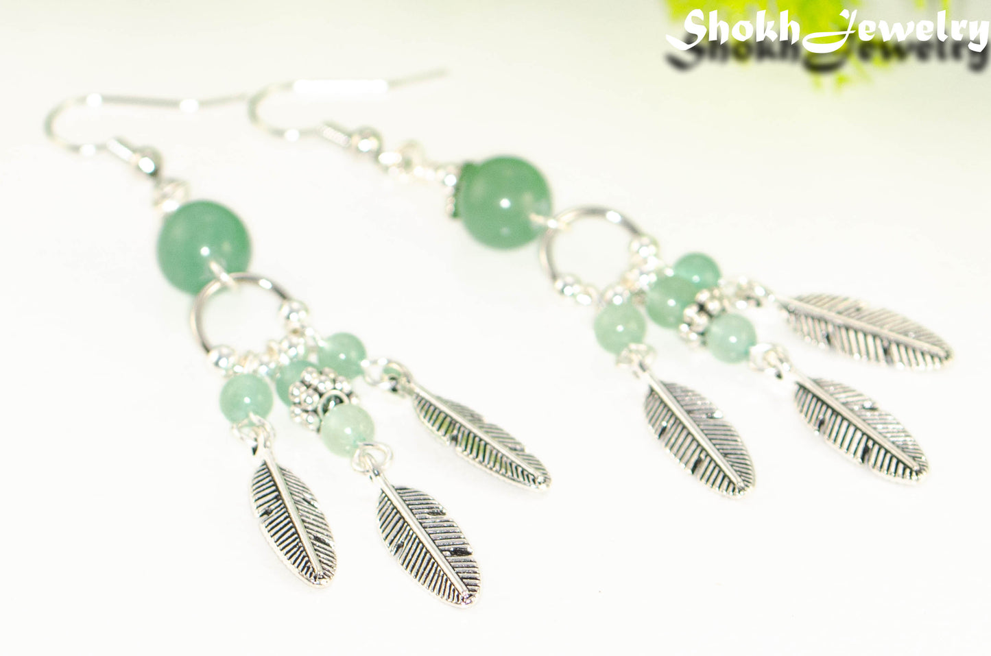 Close up of Statement Green Aventurine Crystal And Feather Earrings.
