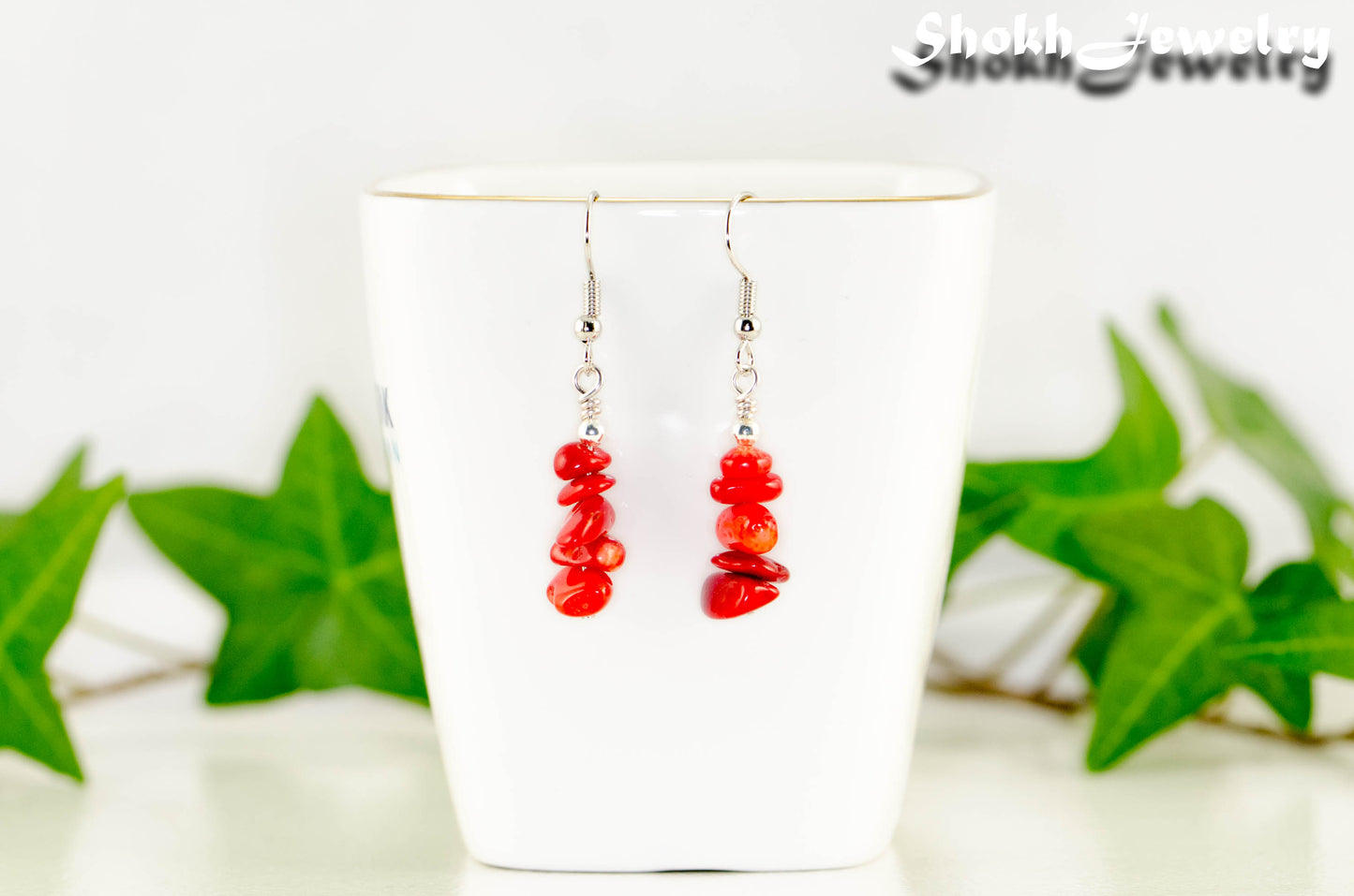 Natural Red Coral Chip Earrings displayed on a tea cup