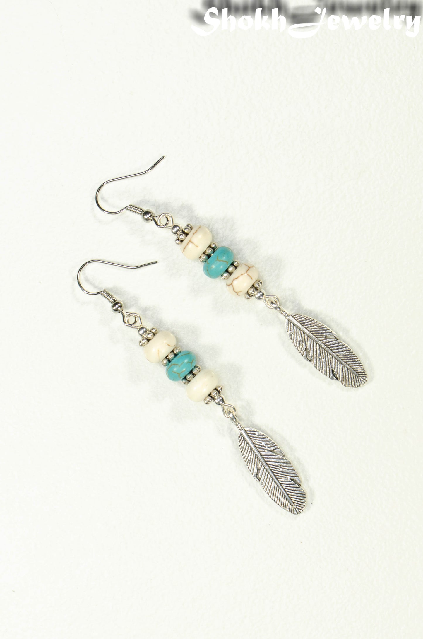 Top view of Statement White And Turquoise Howlite And Feather Earrings
