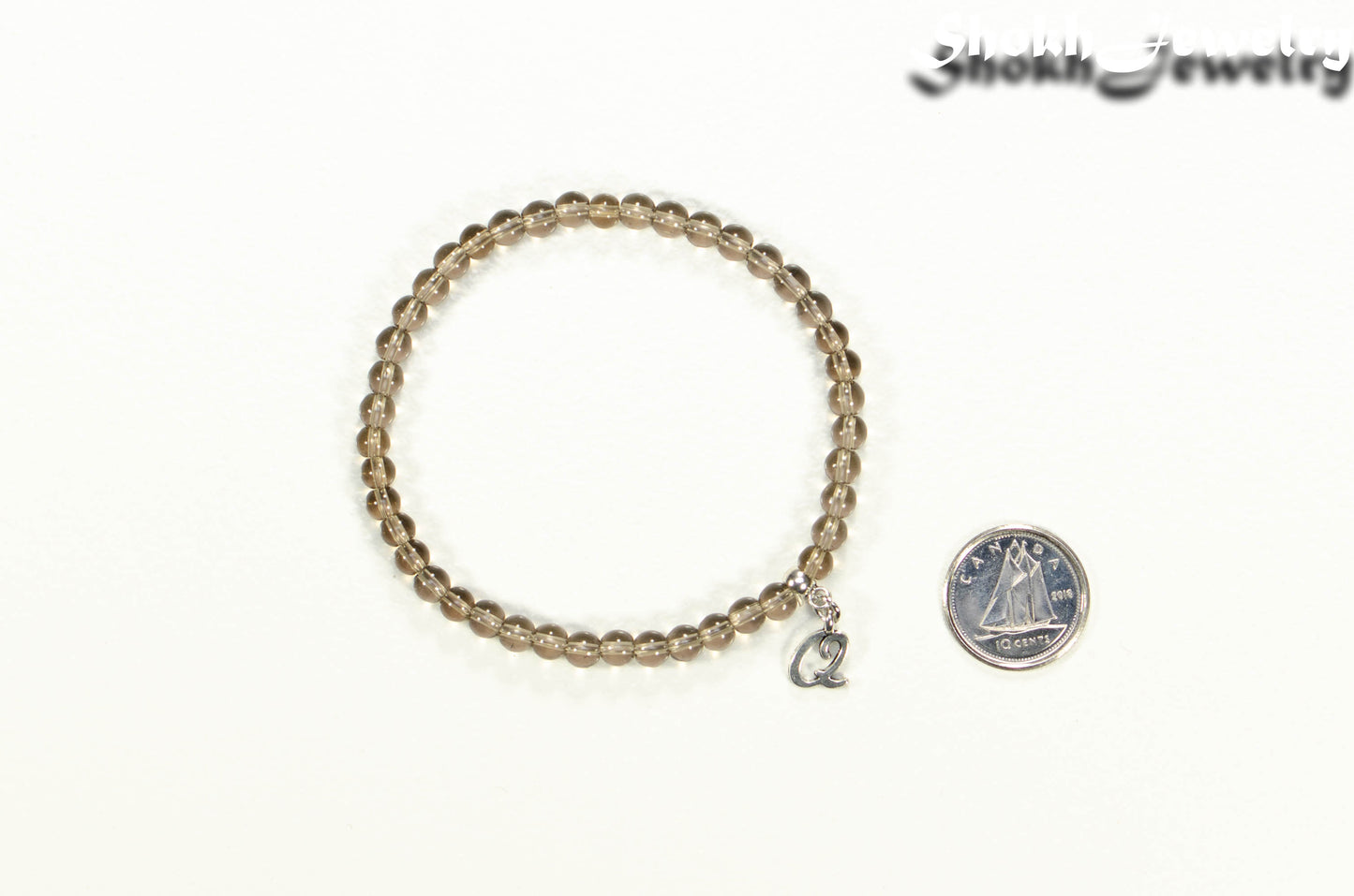 4mm Smoky Quartz Bracelet with Initial beside a dime
