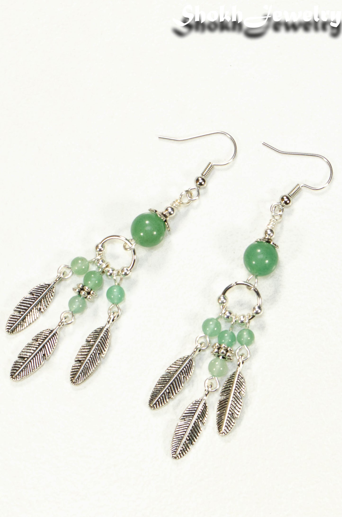 Top view of Statement Green Aventurine Crystal And Feather Earrings.
