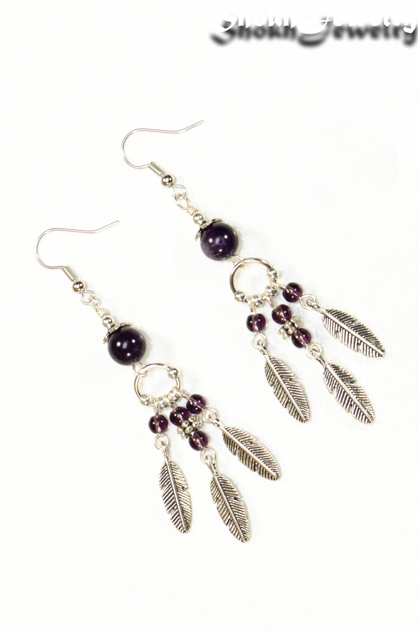 Top view of Statement Amethyst Crystal And Feather Earrings.