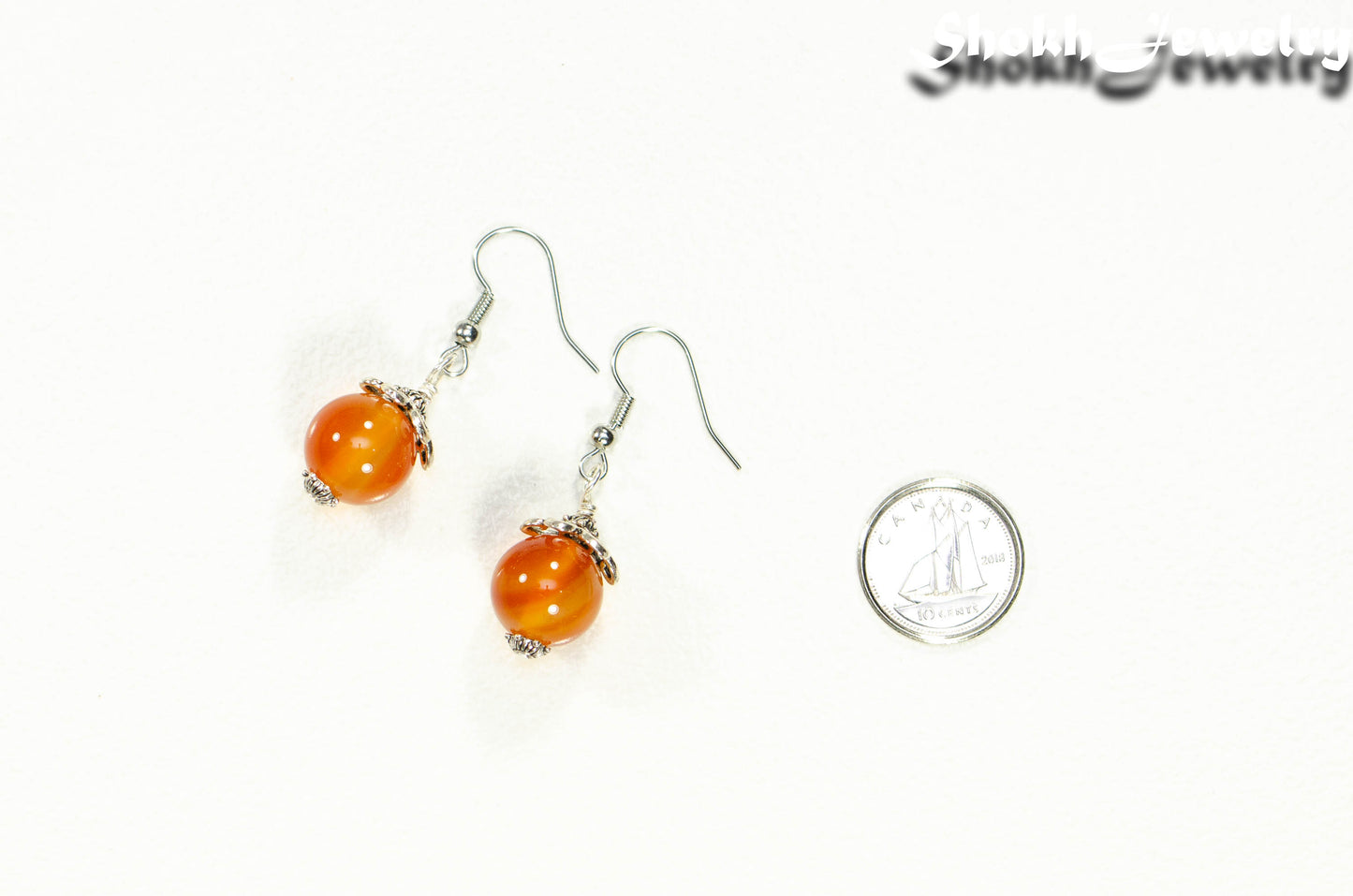 12mm Natural Carnelian Crystal Earrings beside a dime