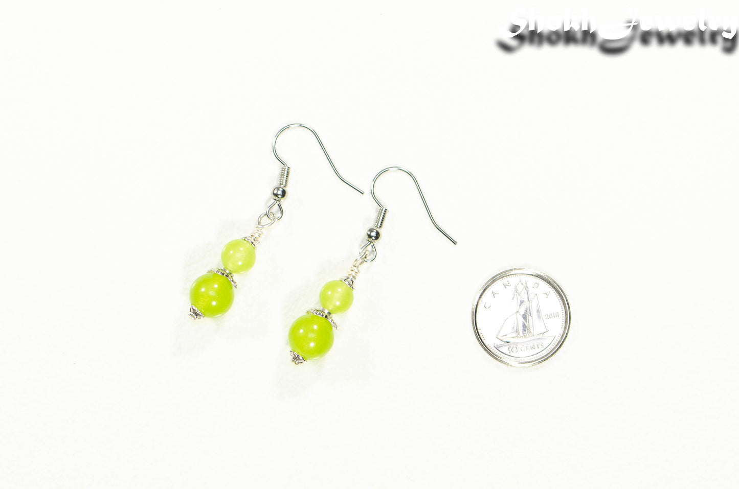 Small Natural Peridot Crystal Earrings beside a dime