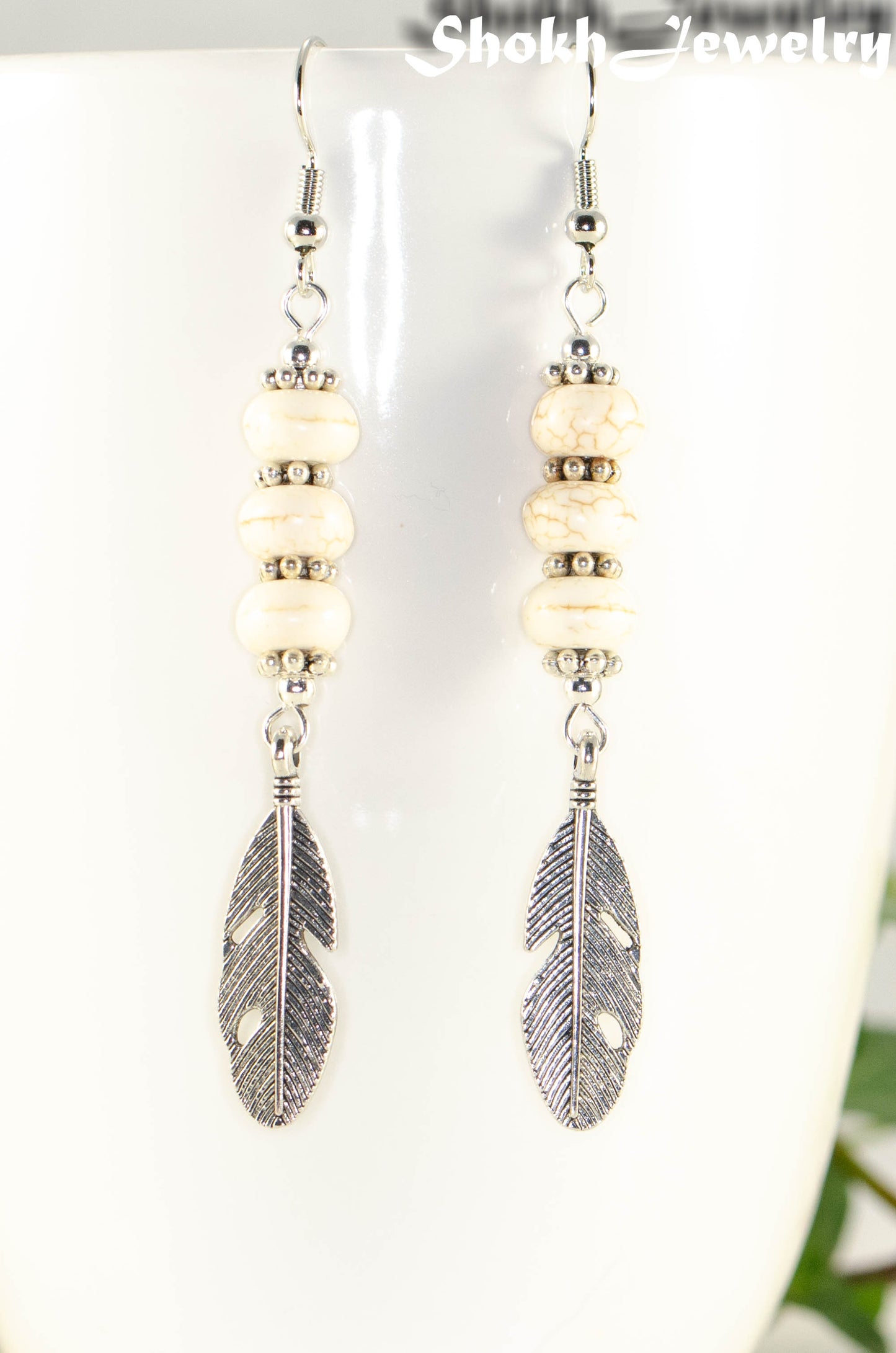 Close up of Statement White Howlite And Tibetan Silver Feather Earrings.
