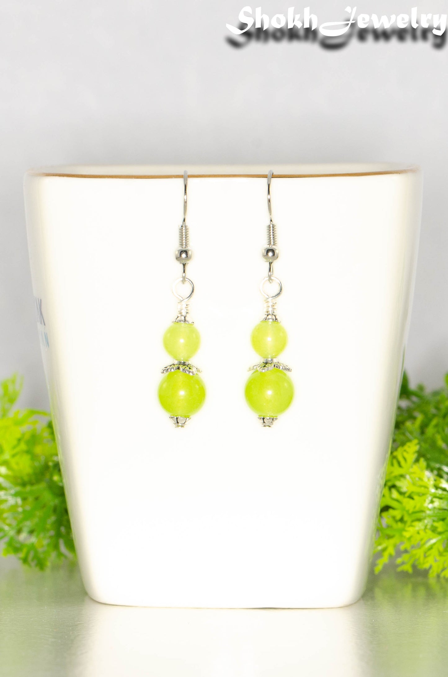Small Natural Peridot Crystal Earrings on a cup