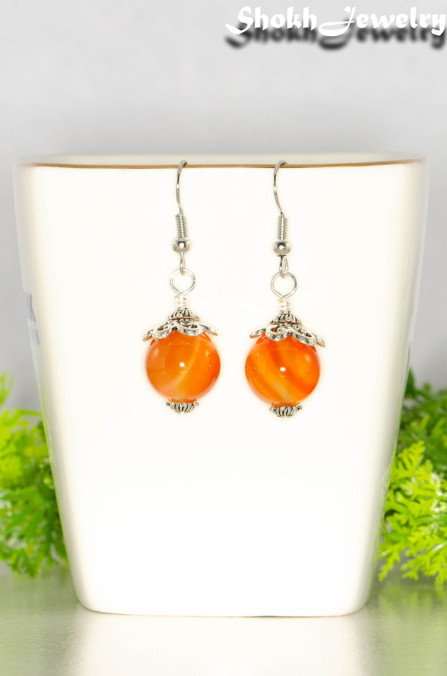 12mm Natural Carnelian Crystal Earrings on a tea cup