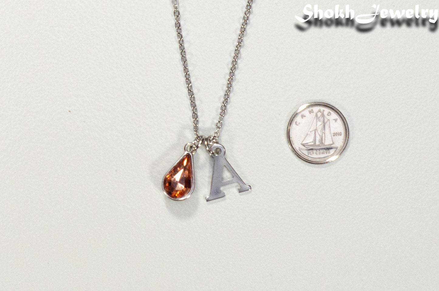 Personalized July Birthstone pendant beside a dime