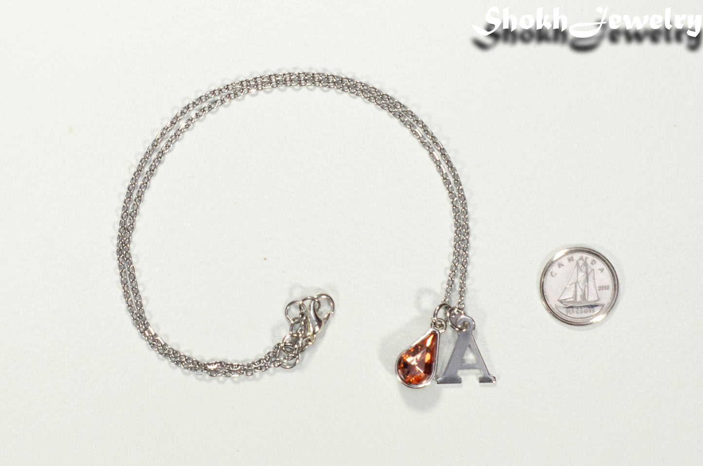 Personalized July Birthstone Choker Necklace beside a dime