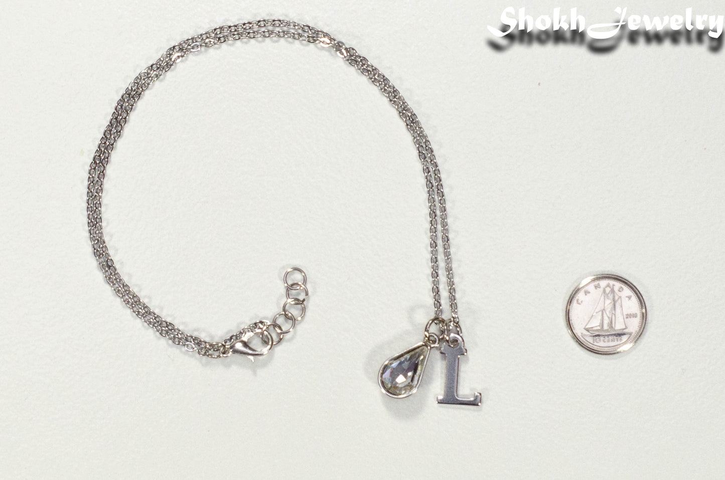 Personalized April Birthstone Choker Necklace beside a dime