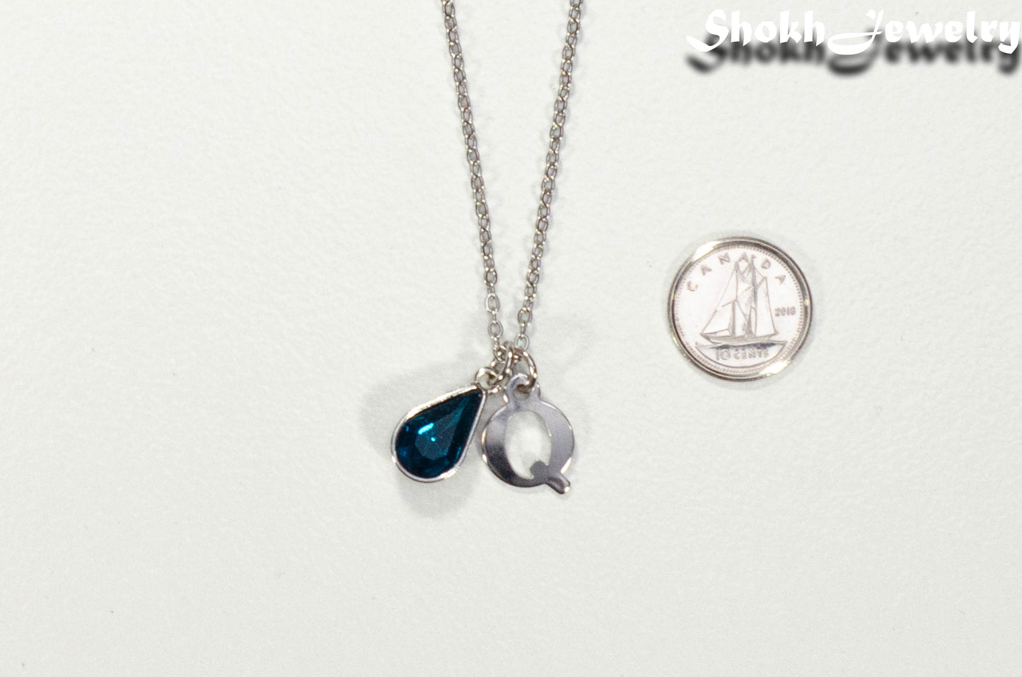 Personalized December Birthstone pendant beside a dime