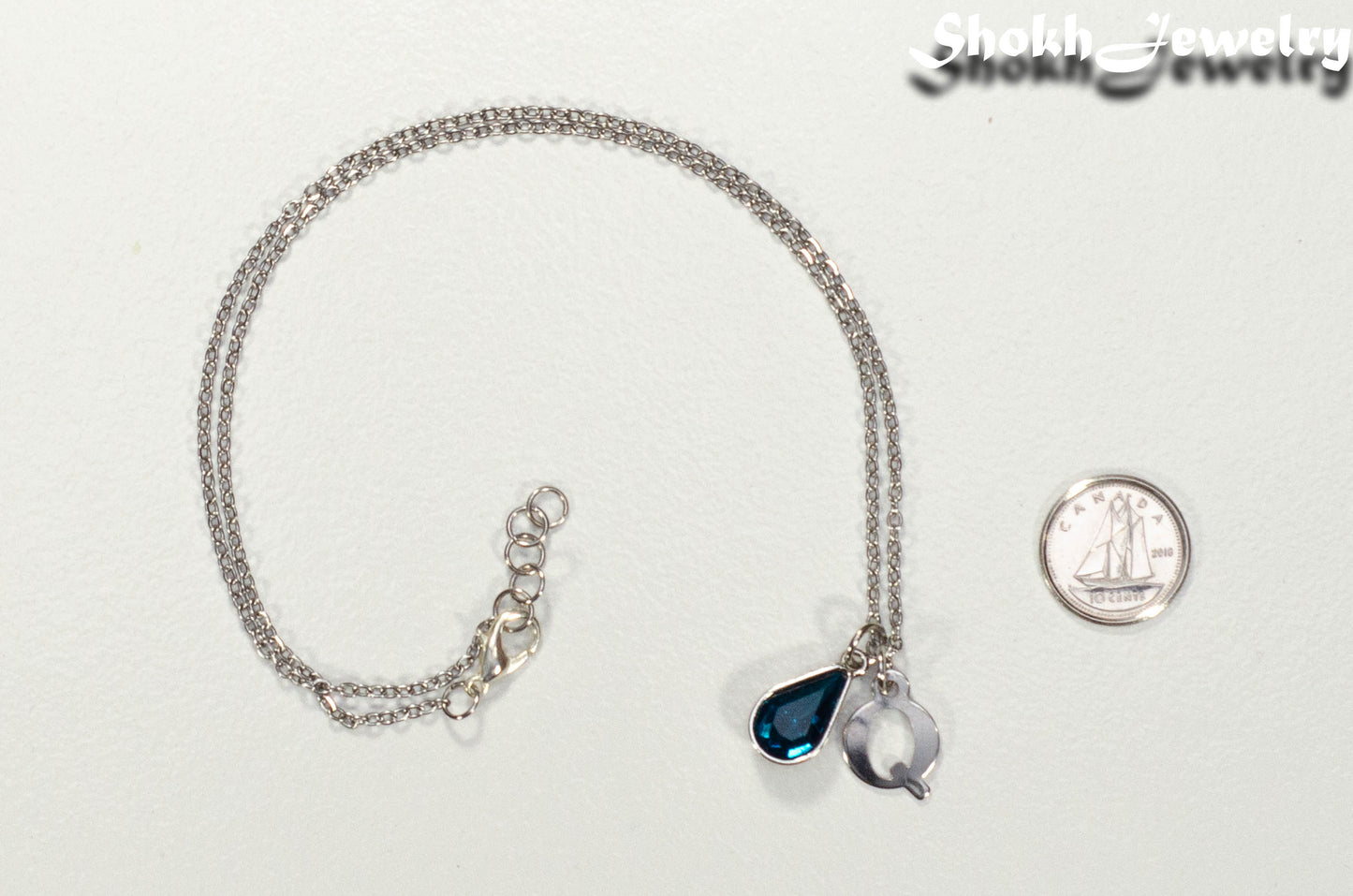 Personalized December Birthstone Choker Necklace beside a dime
