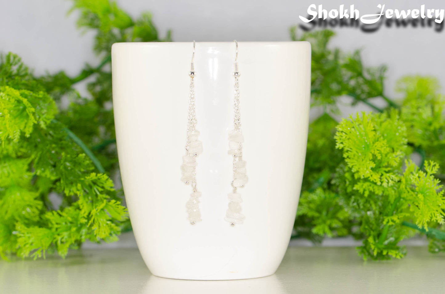 Long Silver Plated Chain and Moonstone Chip Earrings on a mug
