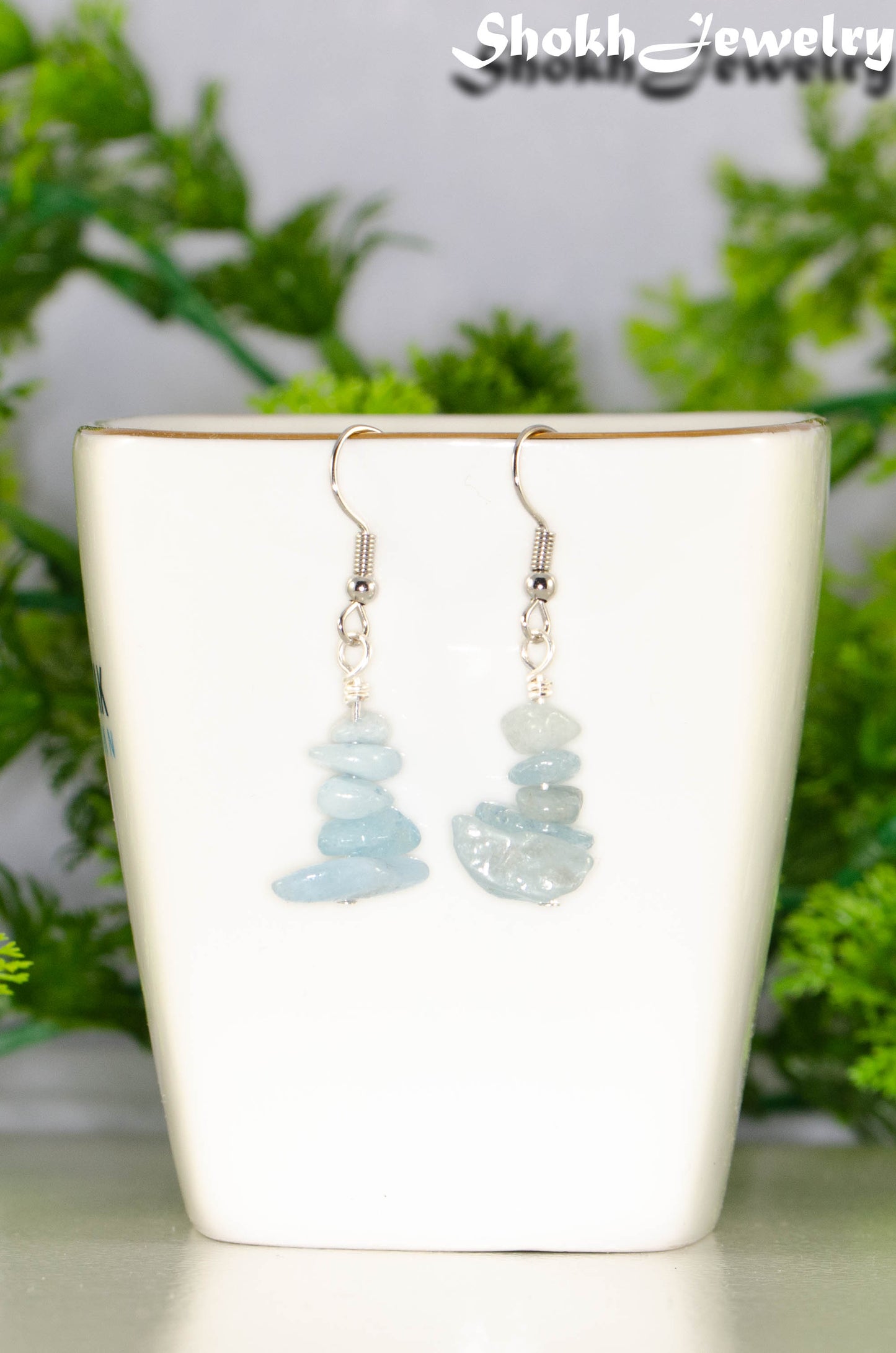 Simple Aquamarine Crystal Chip Earrings displayed on a tea cup.