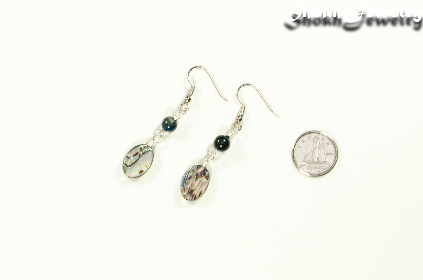 Long Oval Abalone Shell Earrings beside a dime.