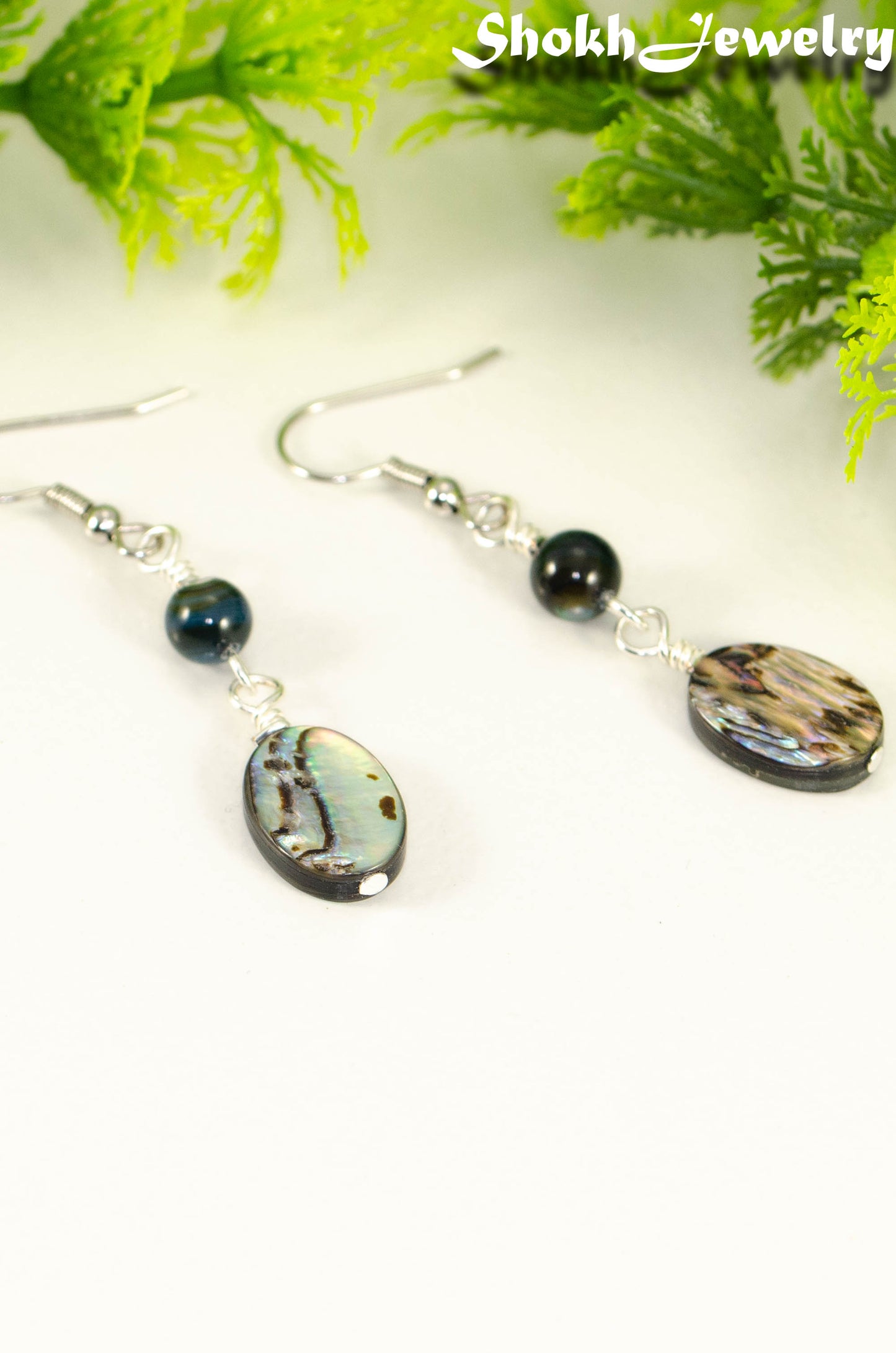 Close up of Long Oval Abalone Shell Earrings.