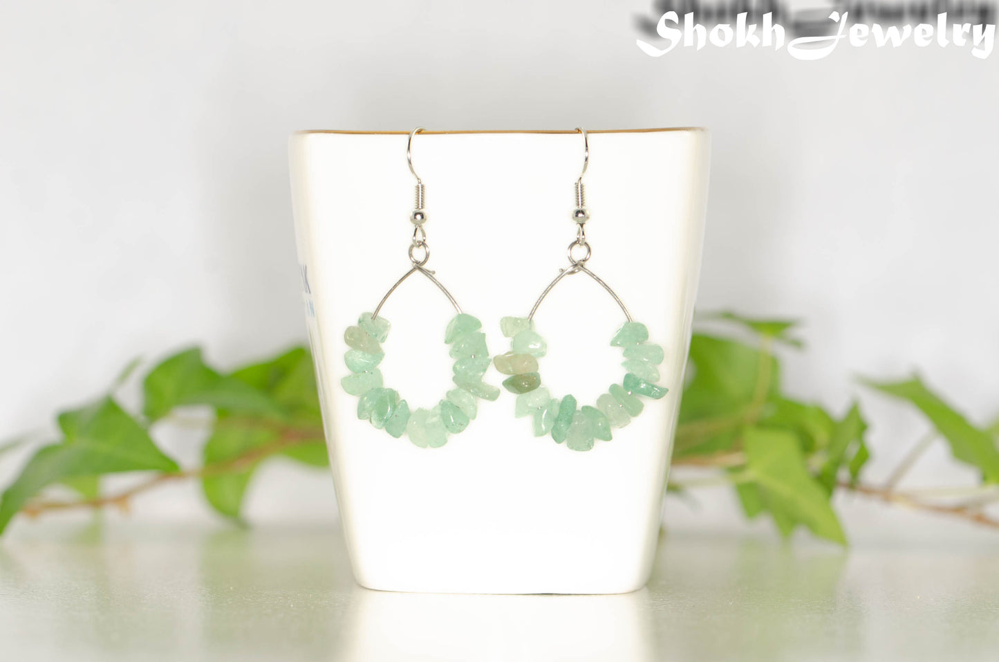 Natural Green Aventurine Crystal Chip Earrings on a tea cup