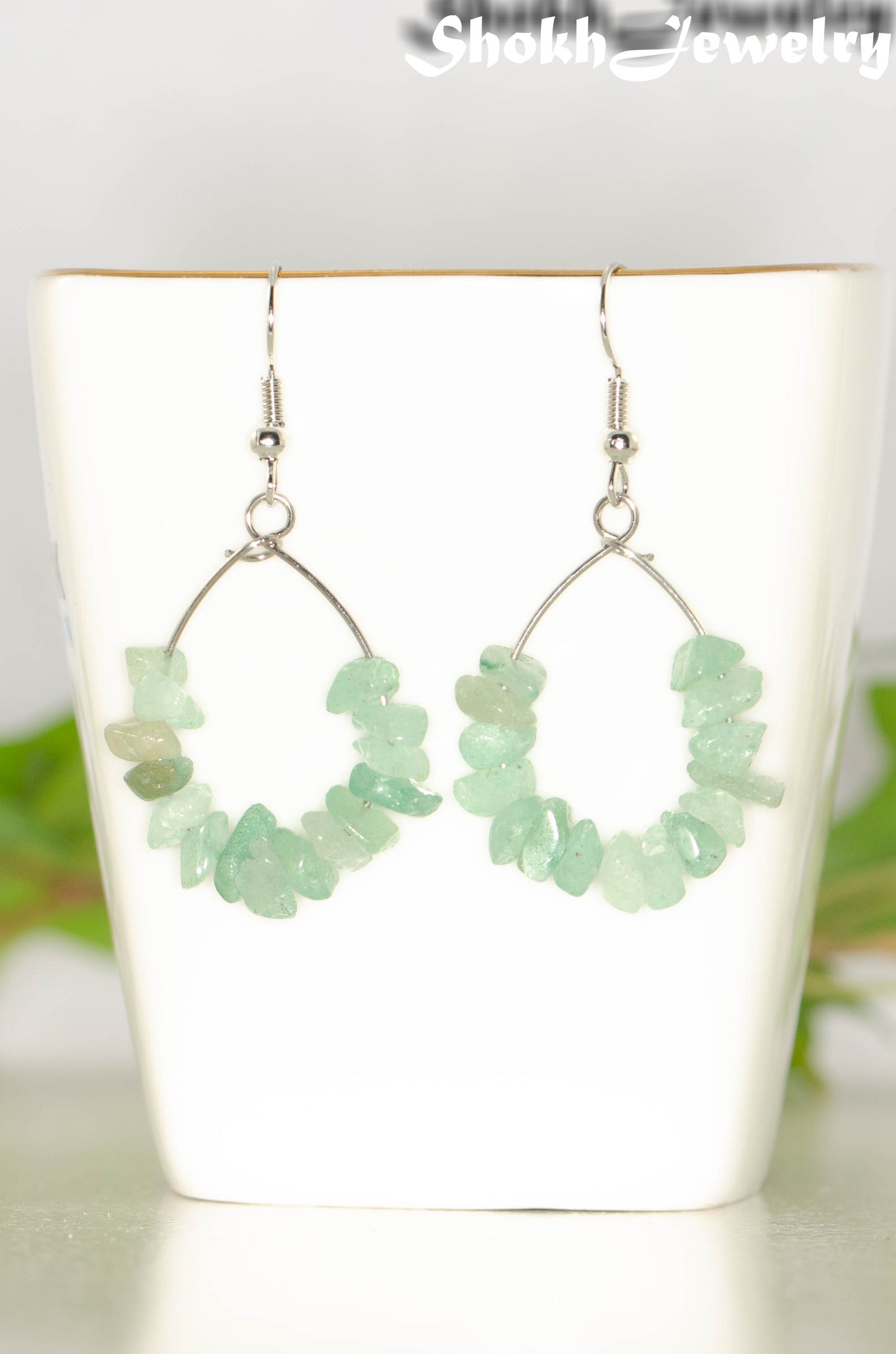 Natural Green Aventurine Crystal Chip Earrings on a tea cup