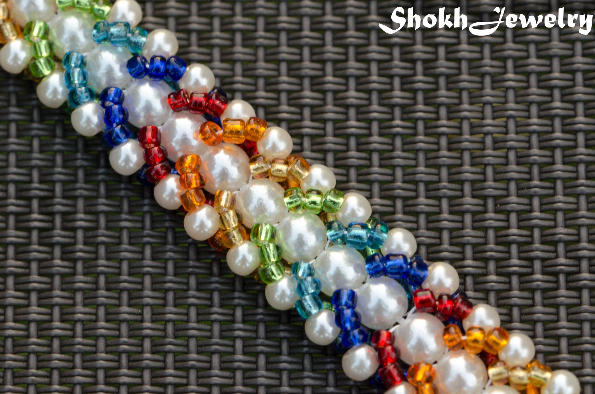 Close up of Rainbow seed bead and pearl woven bracelet.