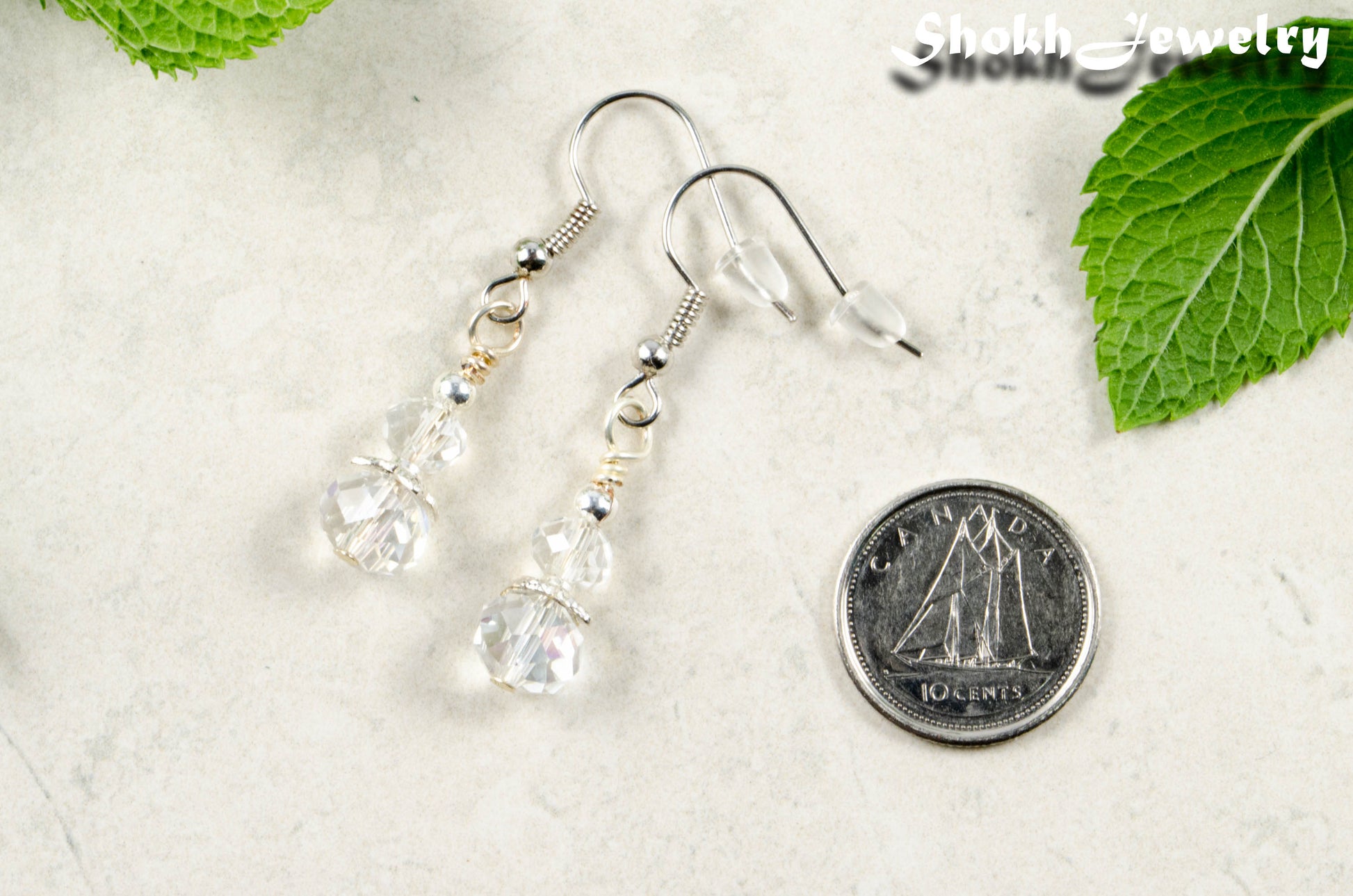 Small Crystal Clear Glass Bead Dangle Earrings beside a dime.
