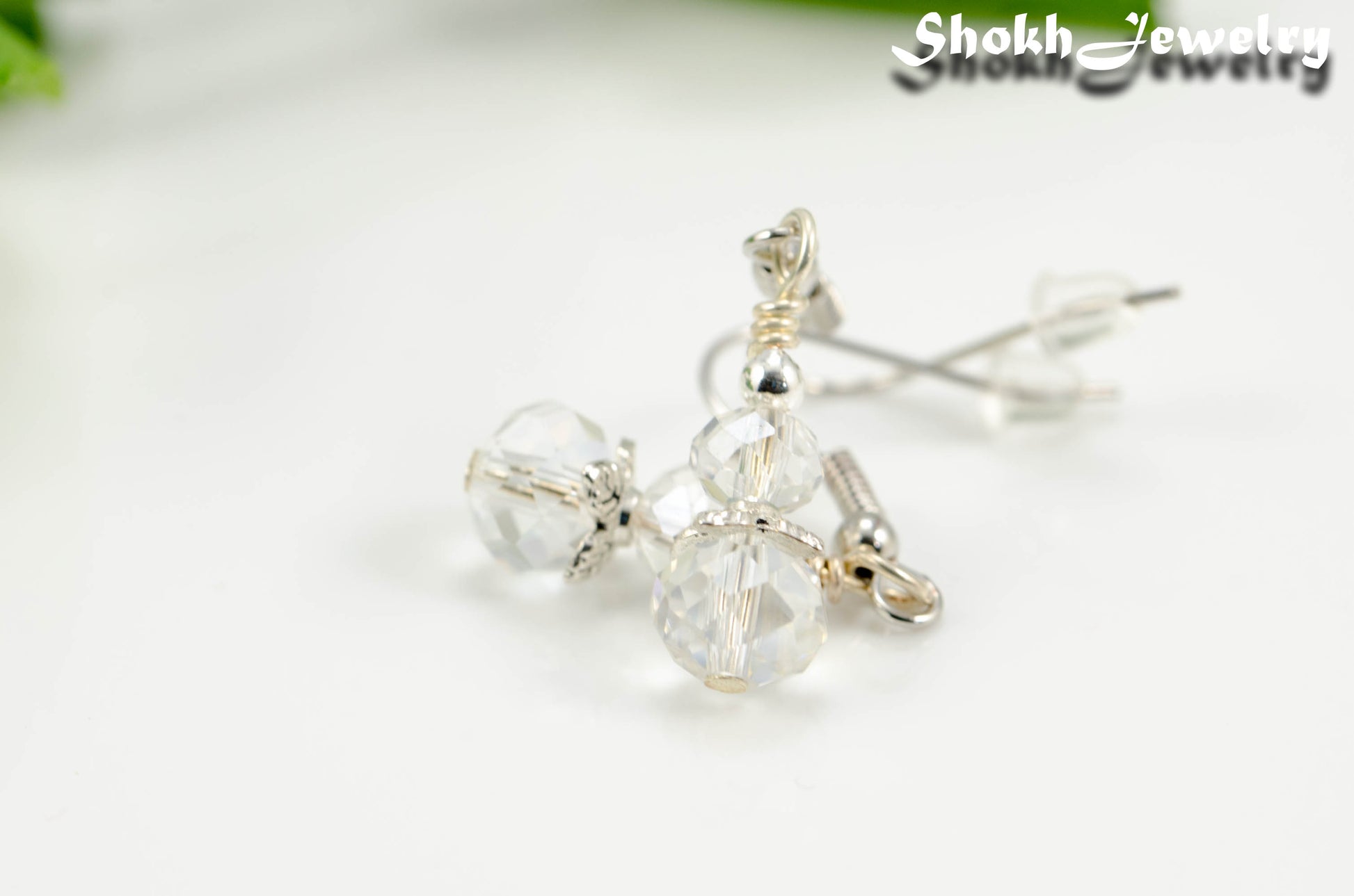 Close up of Small Crystal Clear Glass Bead Dangle Earrings.