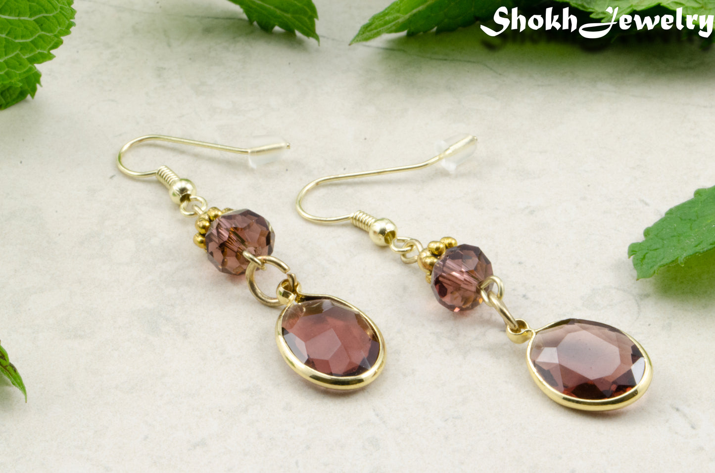 Brown Oval Glass Dangle Earrings with gold tone ear wires.