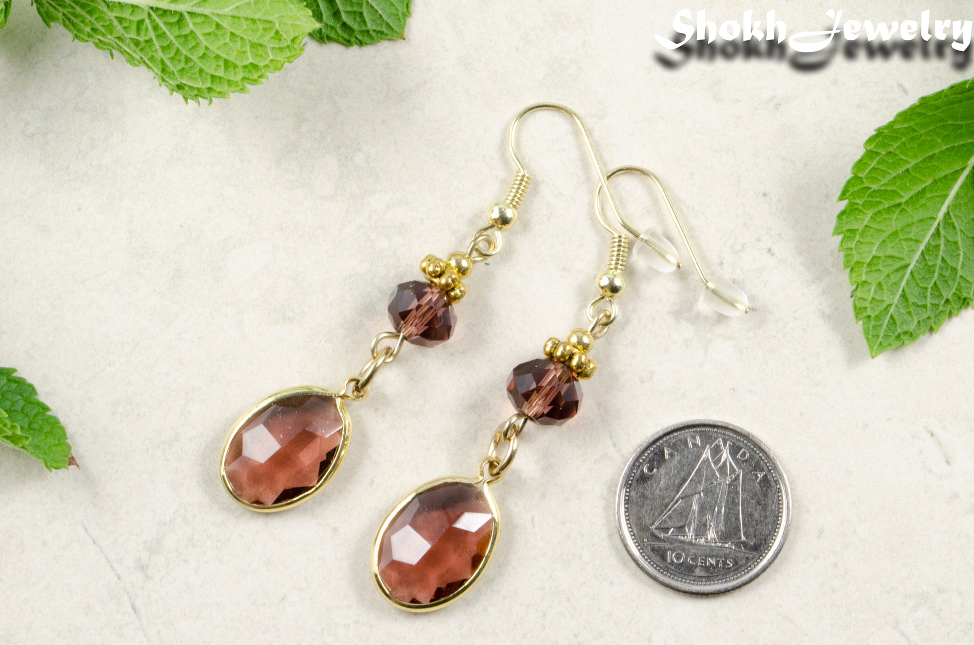 Brown Oval Glass Dangle Earrings beside a dime.