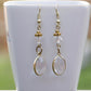 Clear Oval Glass Dangle Earrings displayed on a tea cup.