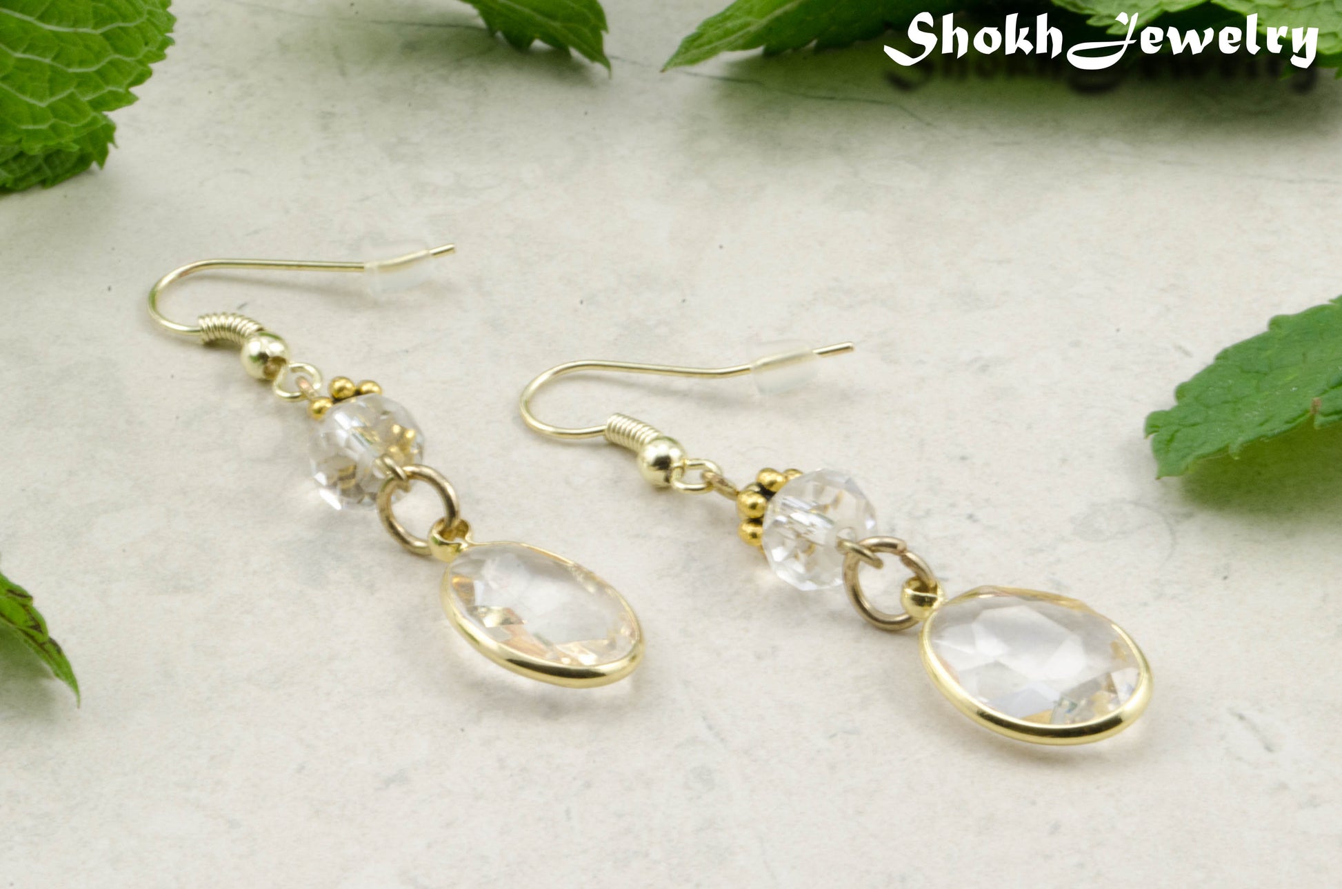 Clear Oval Glass Dangle Earrings with gold tone ear wires.