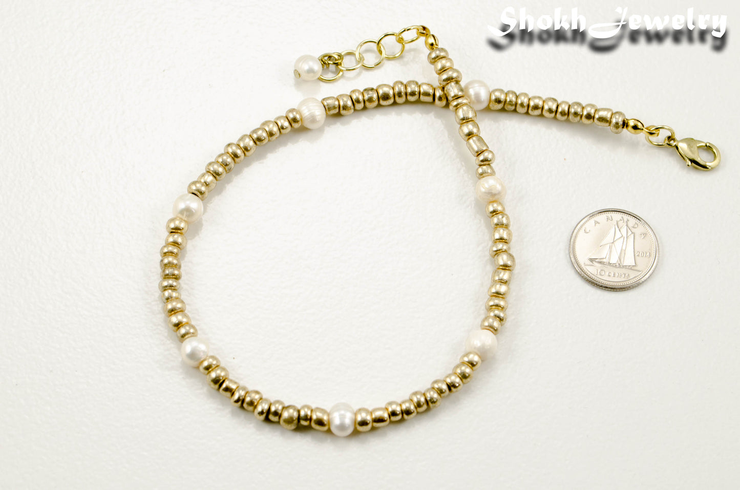 Freshwater Pearl and Gold Seed Bead Anklet beside a dime.