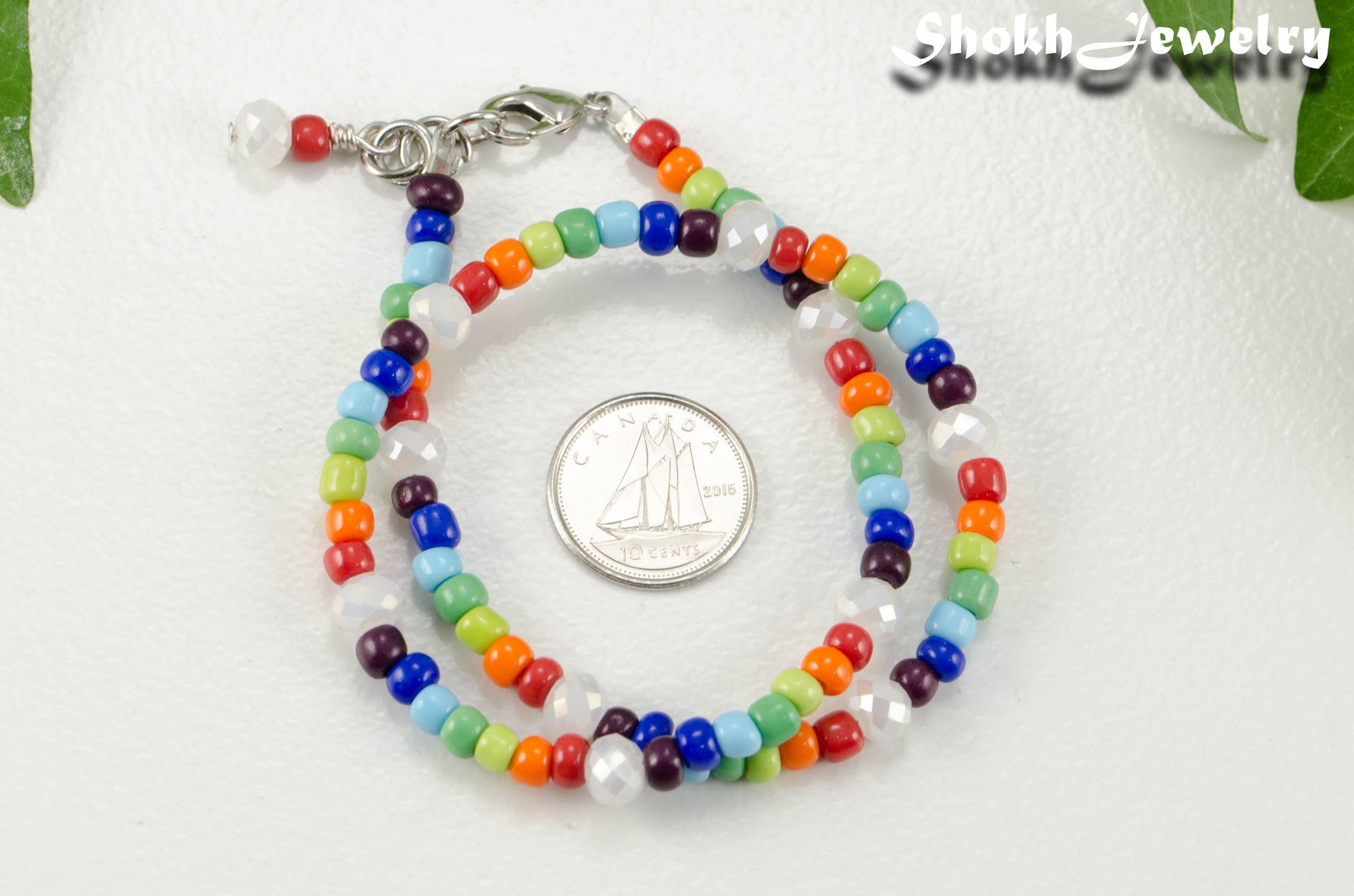 White Glass Crystal and Rainbow Seed Bead Anklet beside a dime.