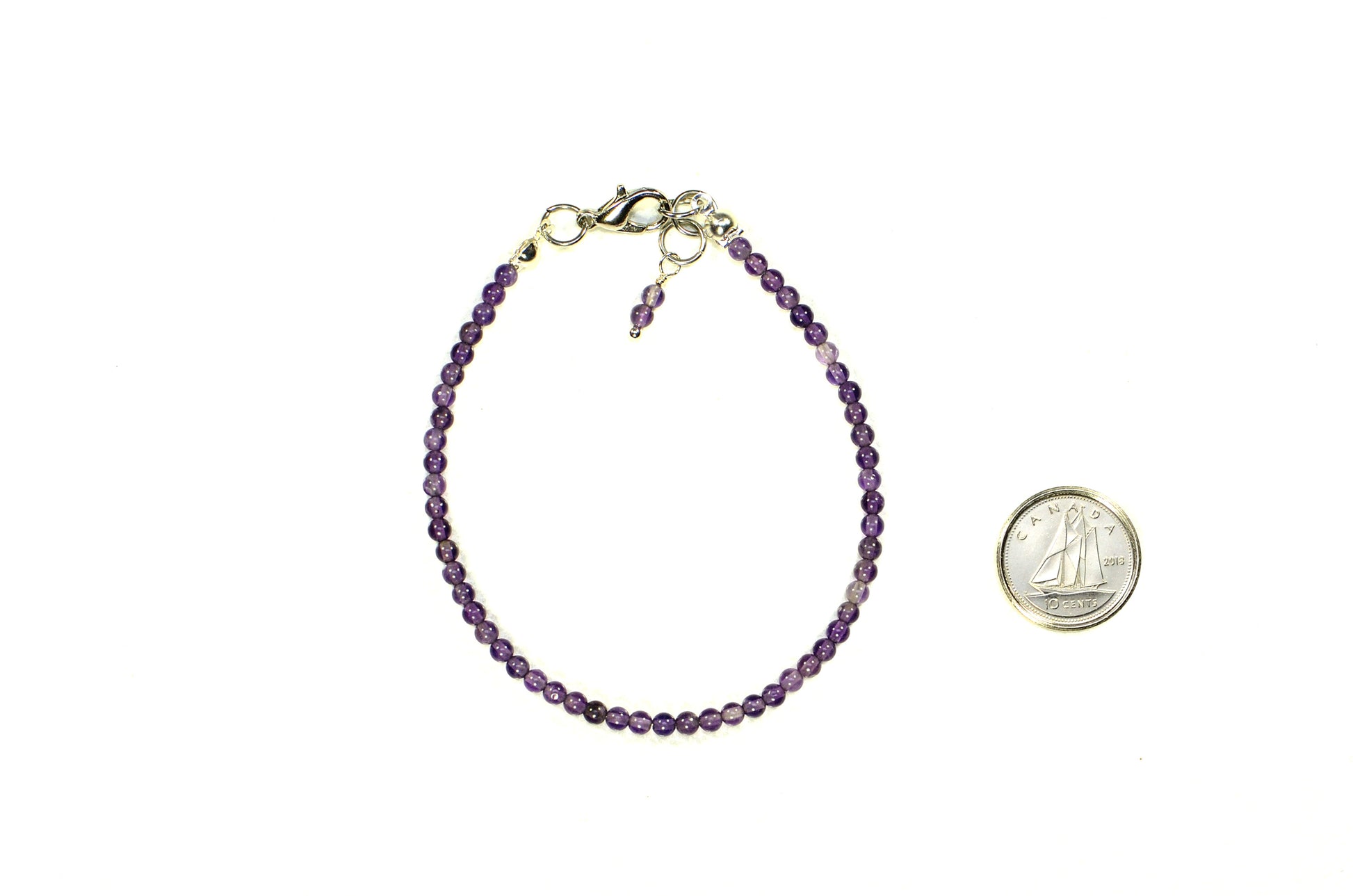 3mm Amethyst Bracelet with Clasp beside a dime.