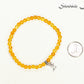 4mm Citrine Bracelet with Initial beside a dime.