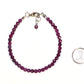 4mm Faceted Ruby Anklet beside a dime.