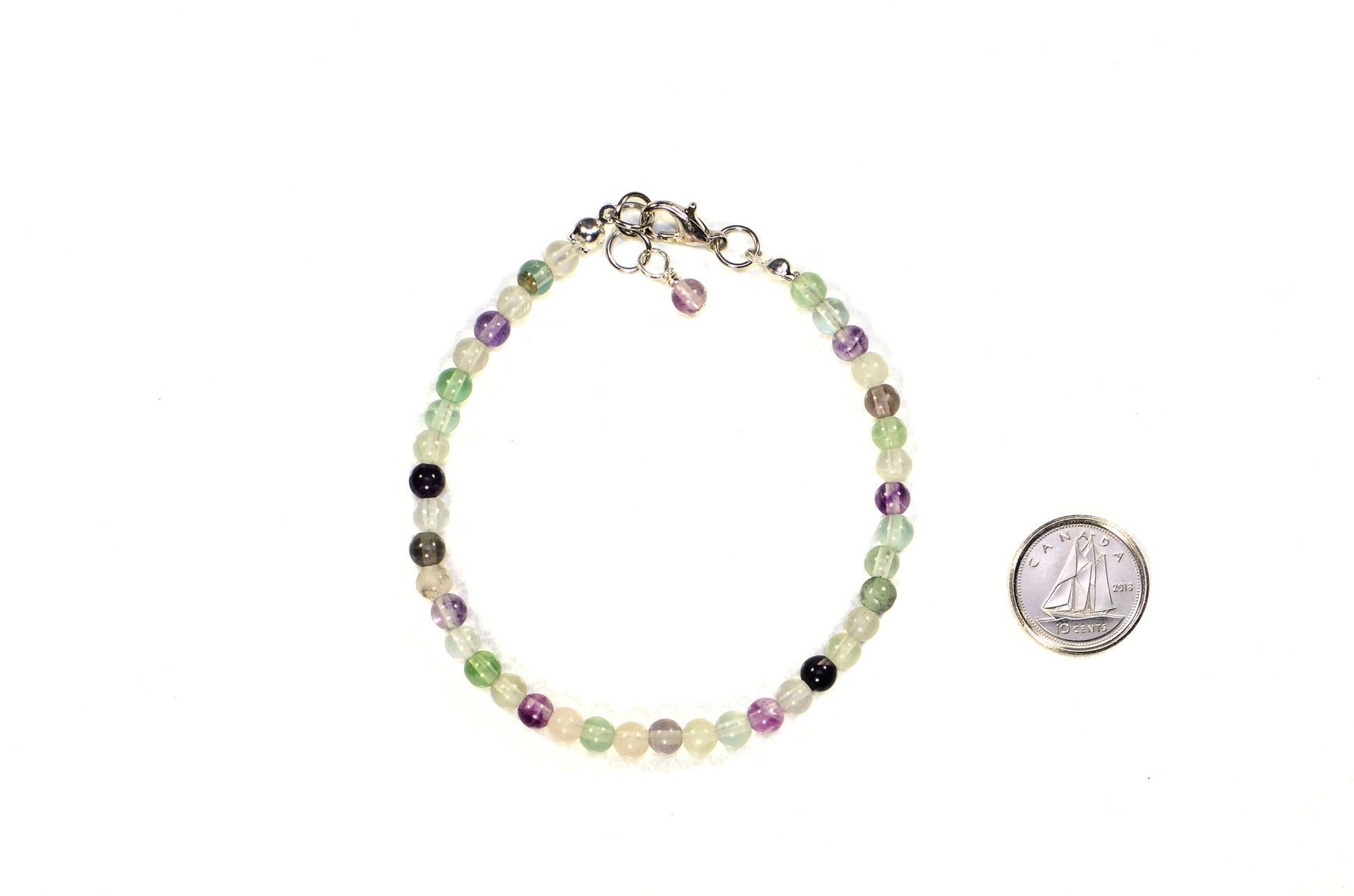 4mm Natural Rainbow Fluorite Bracelet with Clasp beside a dime.