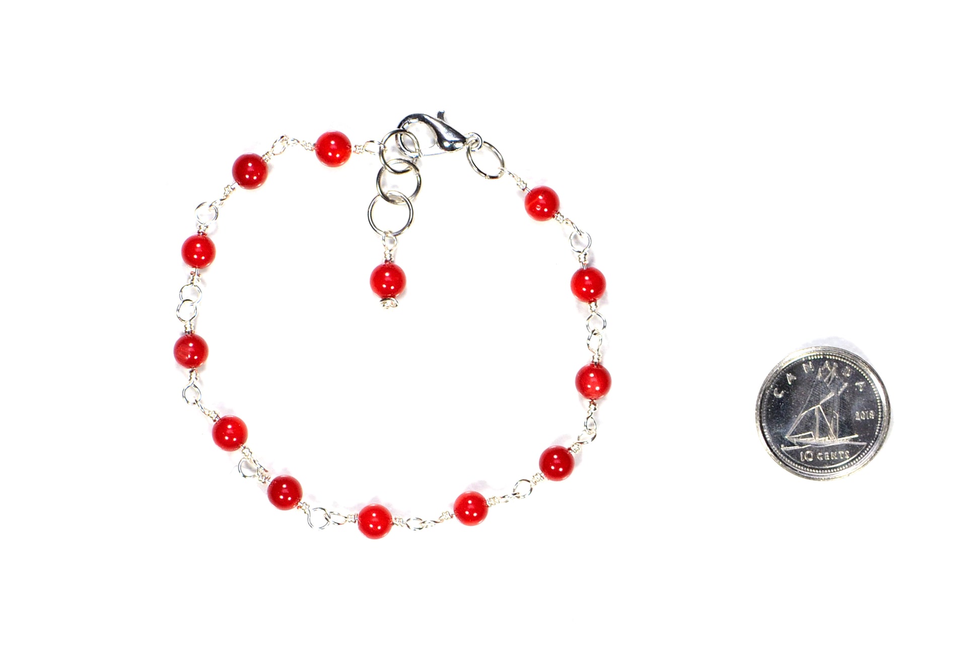 4mm Natural Red Dyed Coral Link Bracelet beside a dime.
