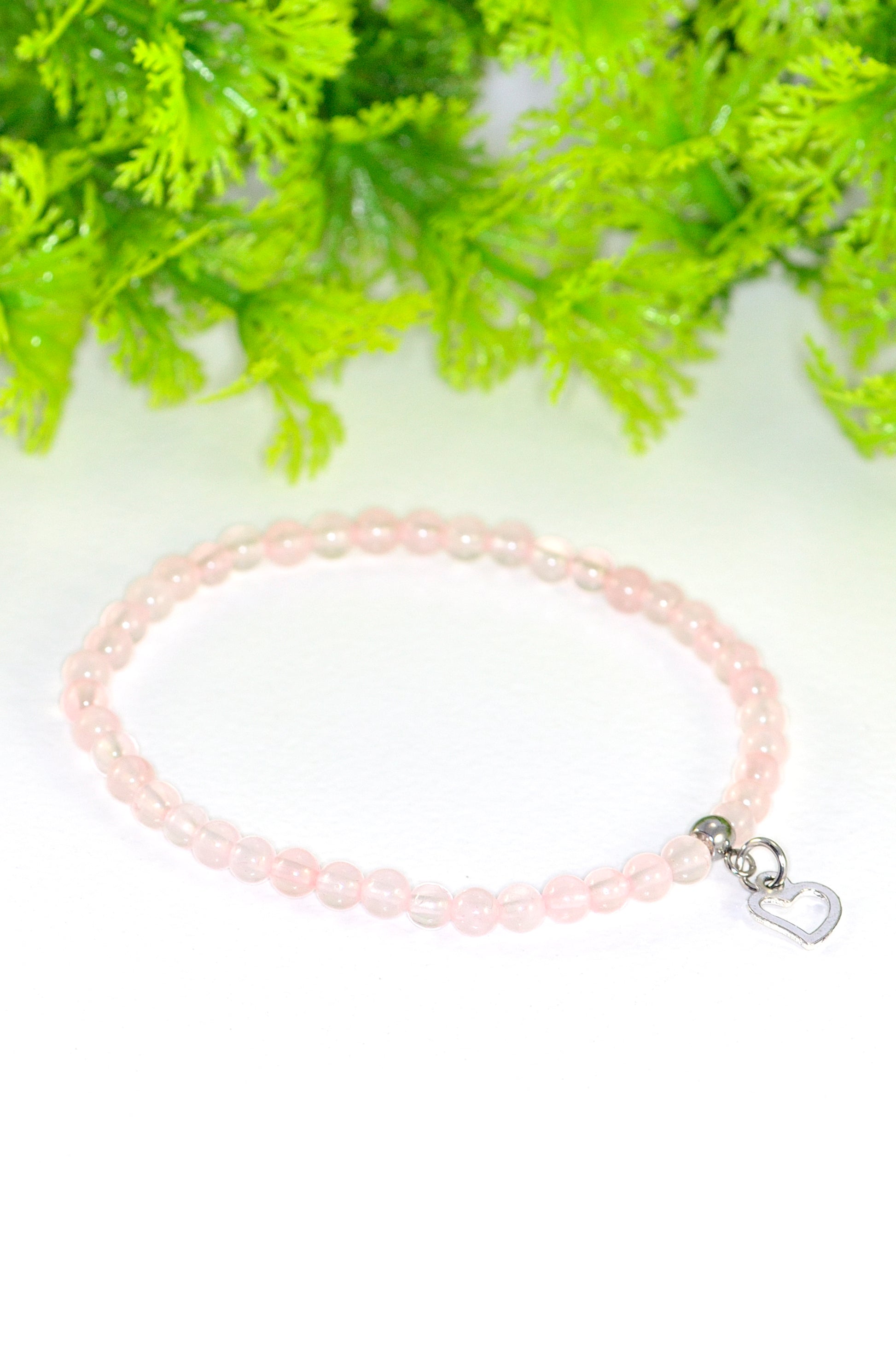 Close up of 4mm Rose Quartz Bracelet with Heart Charm.