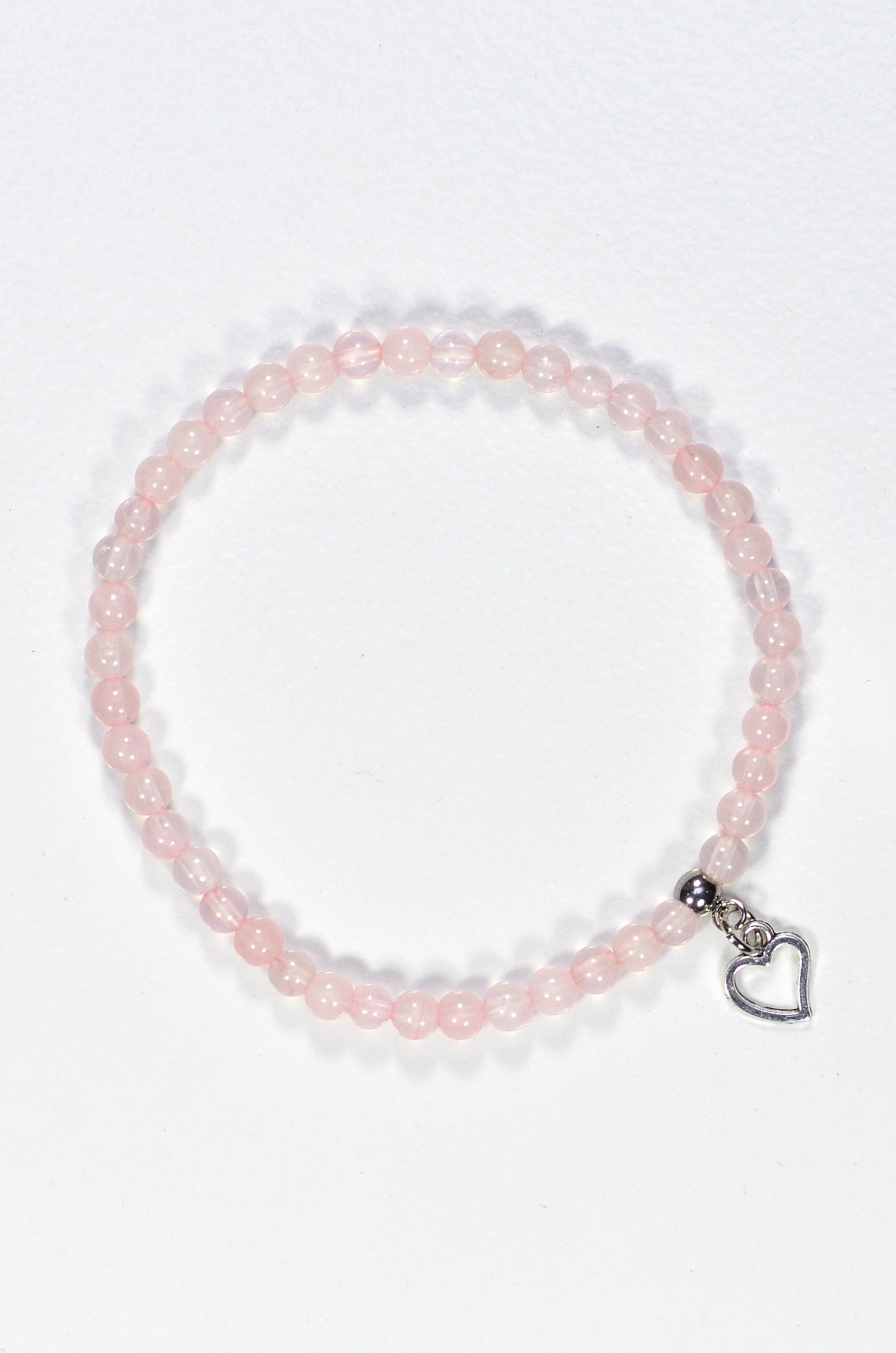 Top view of 4mm Rose Quartz Bracelet with Heart Charm.