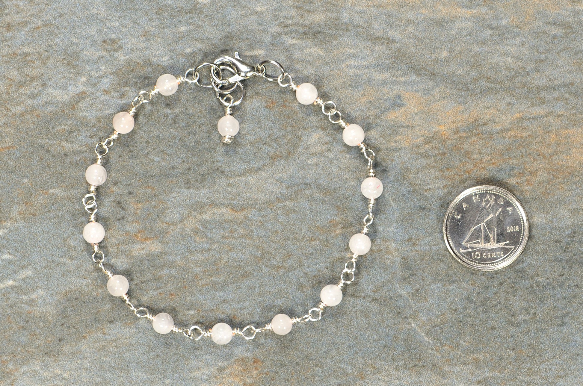 4mm Rose Quartz Link Bracelet beside a dime.