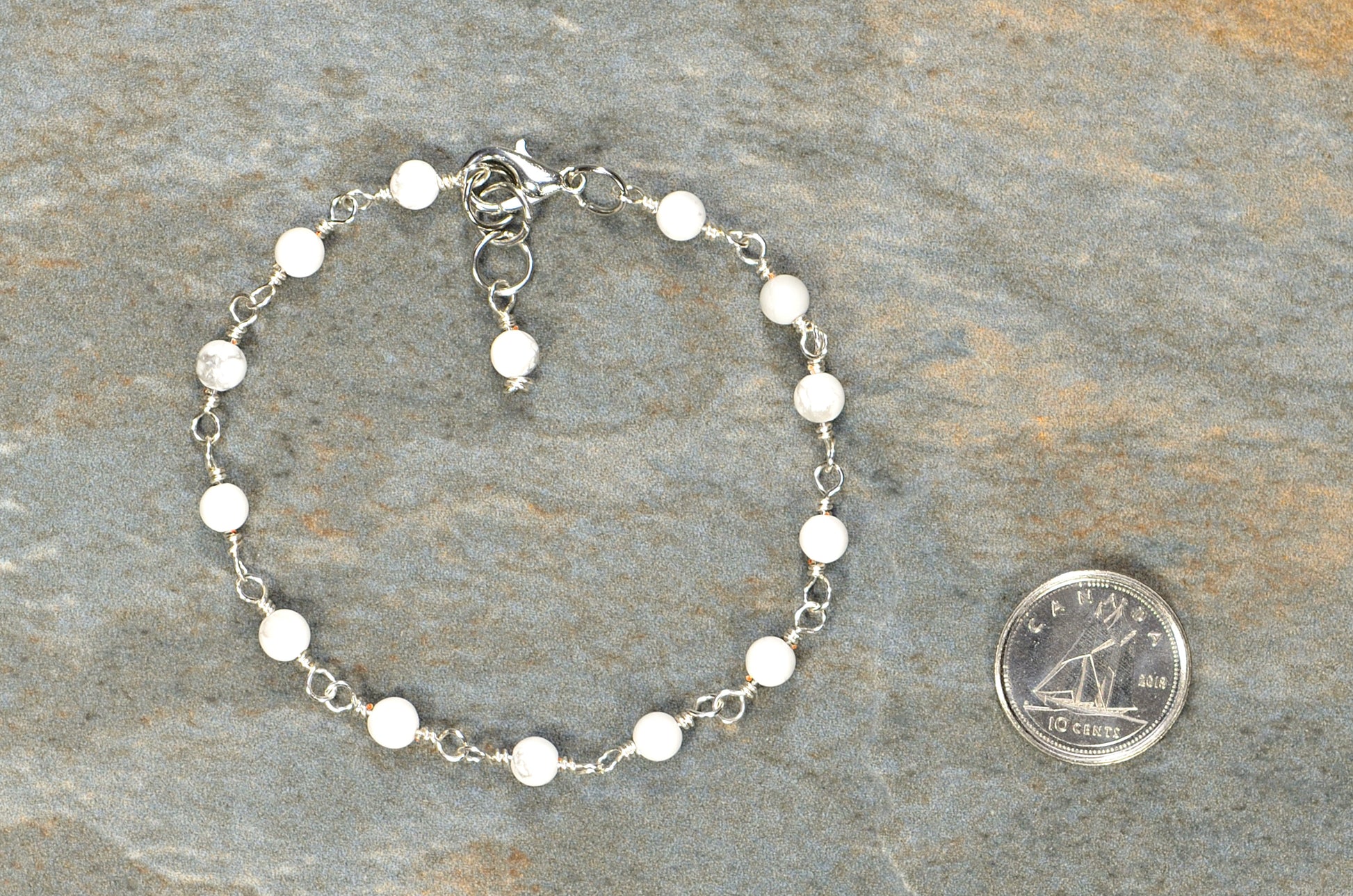 4mm White Howlite Link Bracelet beside a dime.