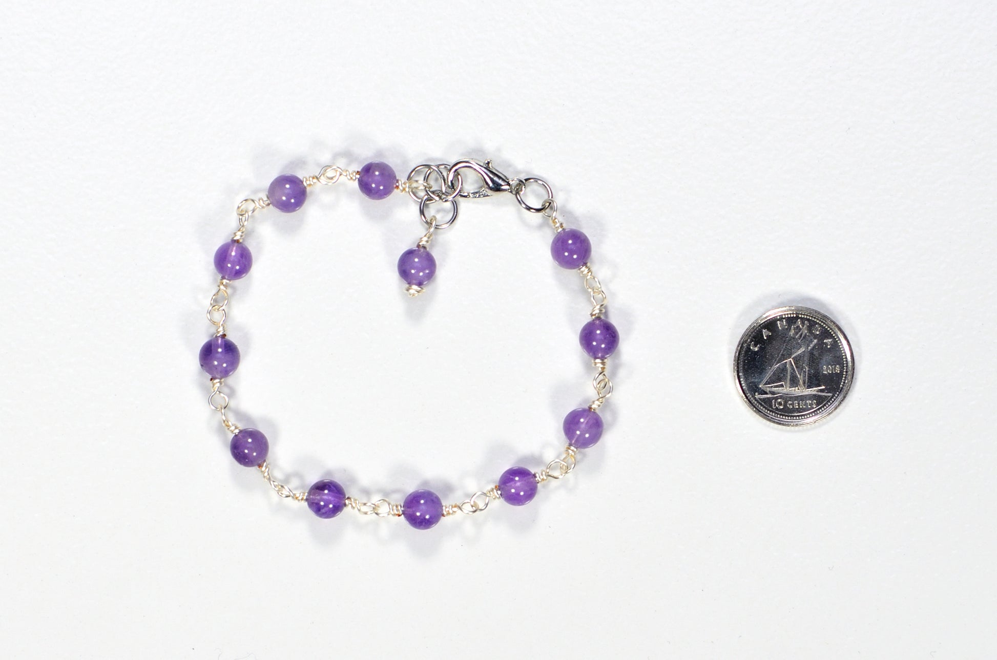 Handmade 6mm Amethyst Link Bracelet beside a dime.