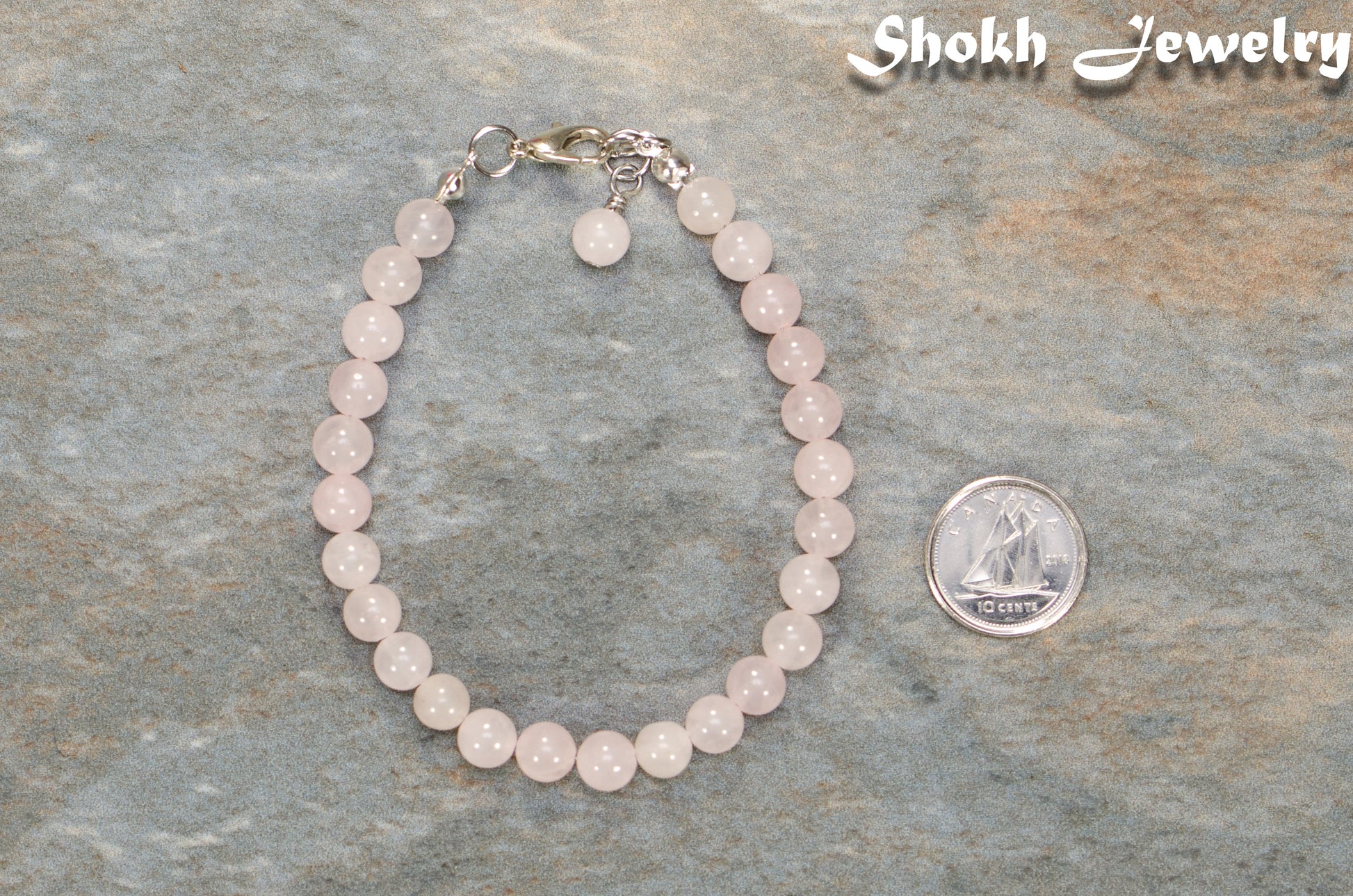 6mm Rose Quartz Beaded Bracelet beside a dime.
