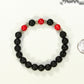 8mm Black Lava Stone and Red Howlite Bracelet beside a dime.