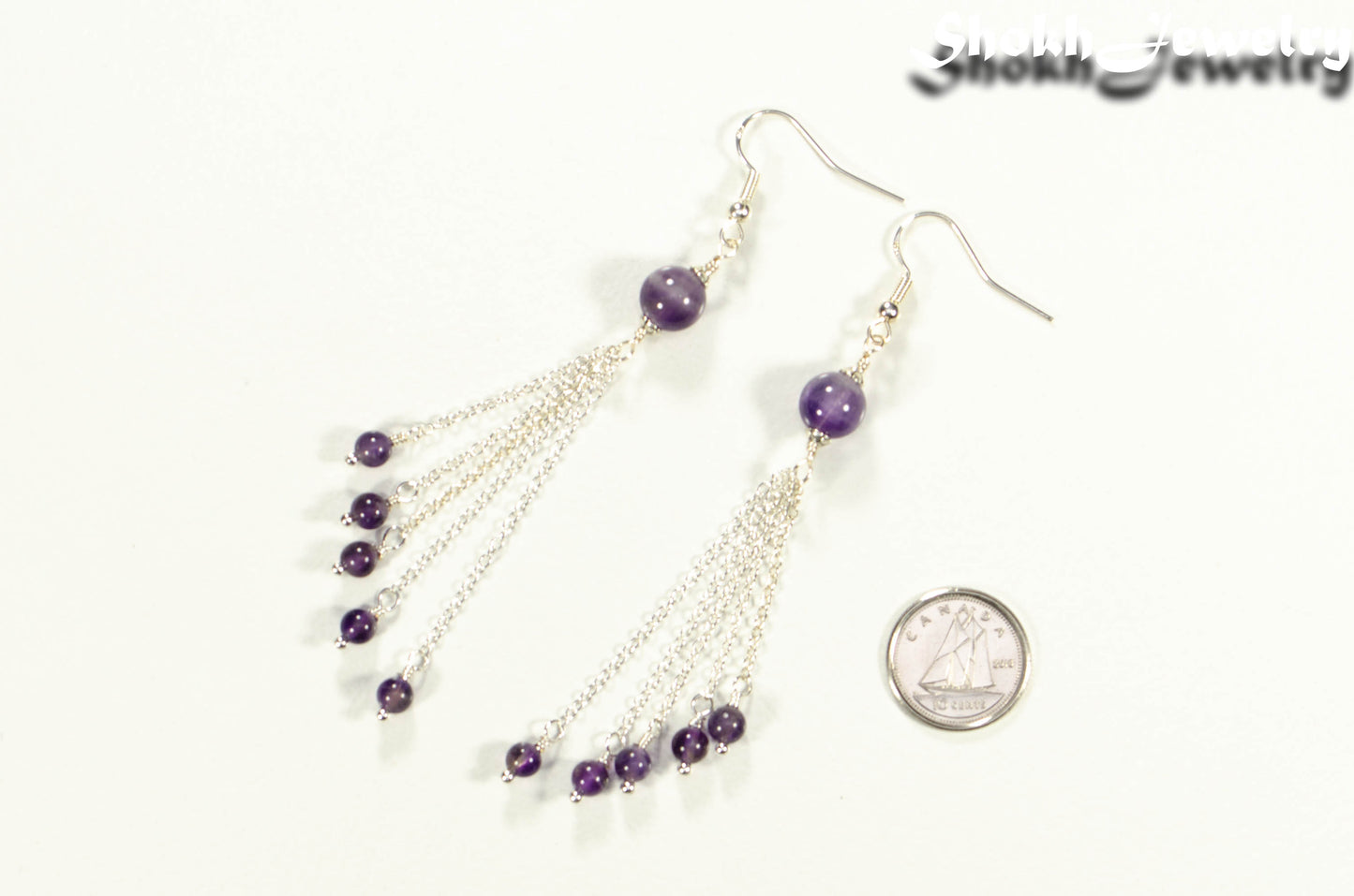 Cascading Amethyst Crystal Drop Earrings beside a dime.